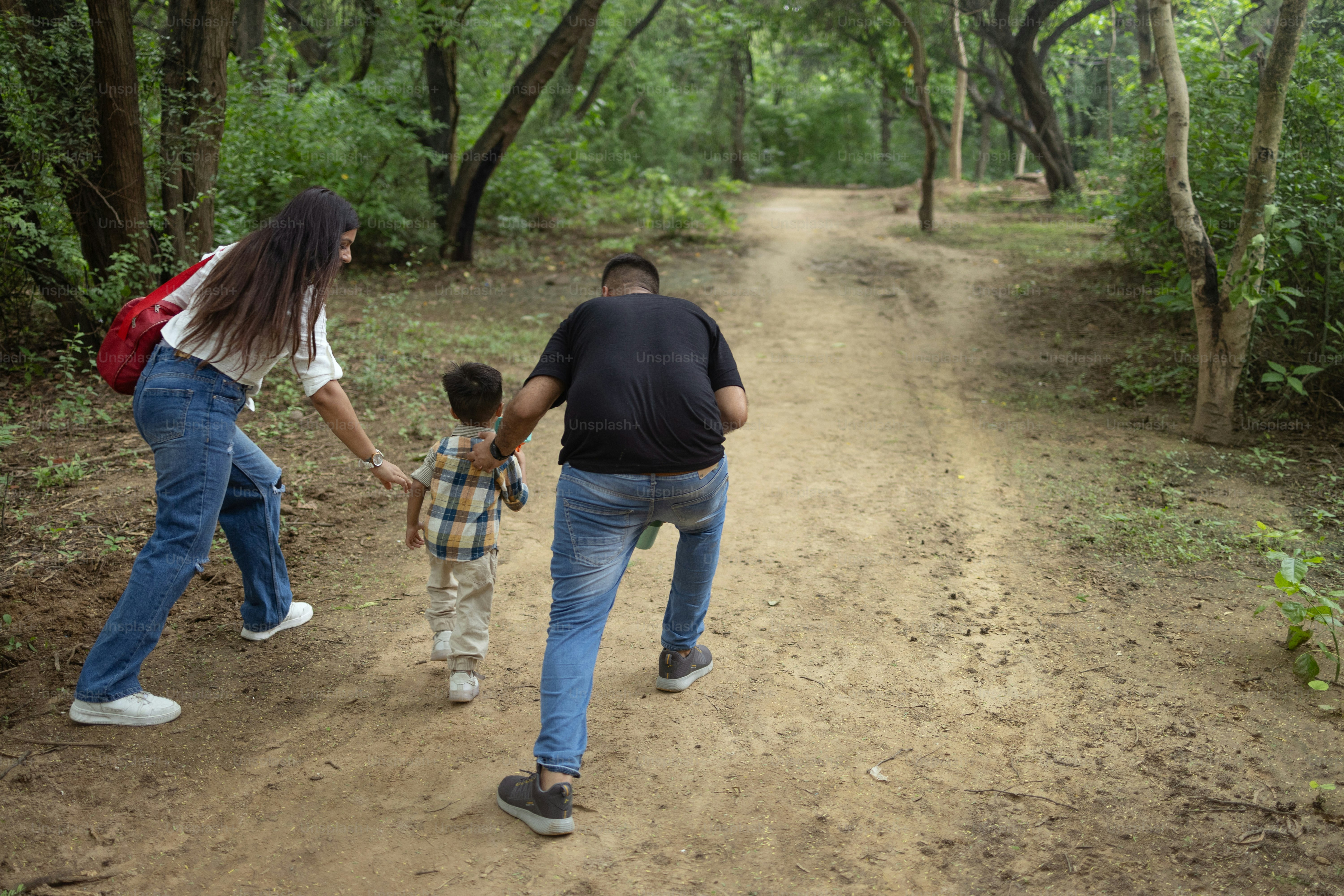 A family walking down a dirt road in the woods