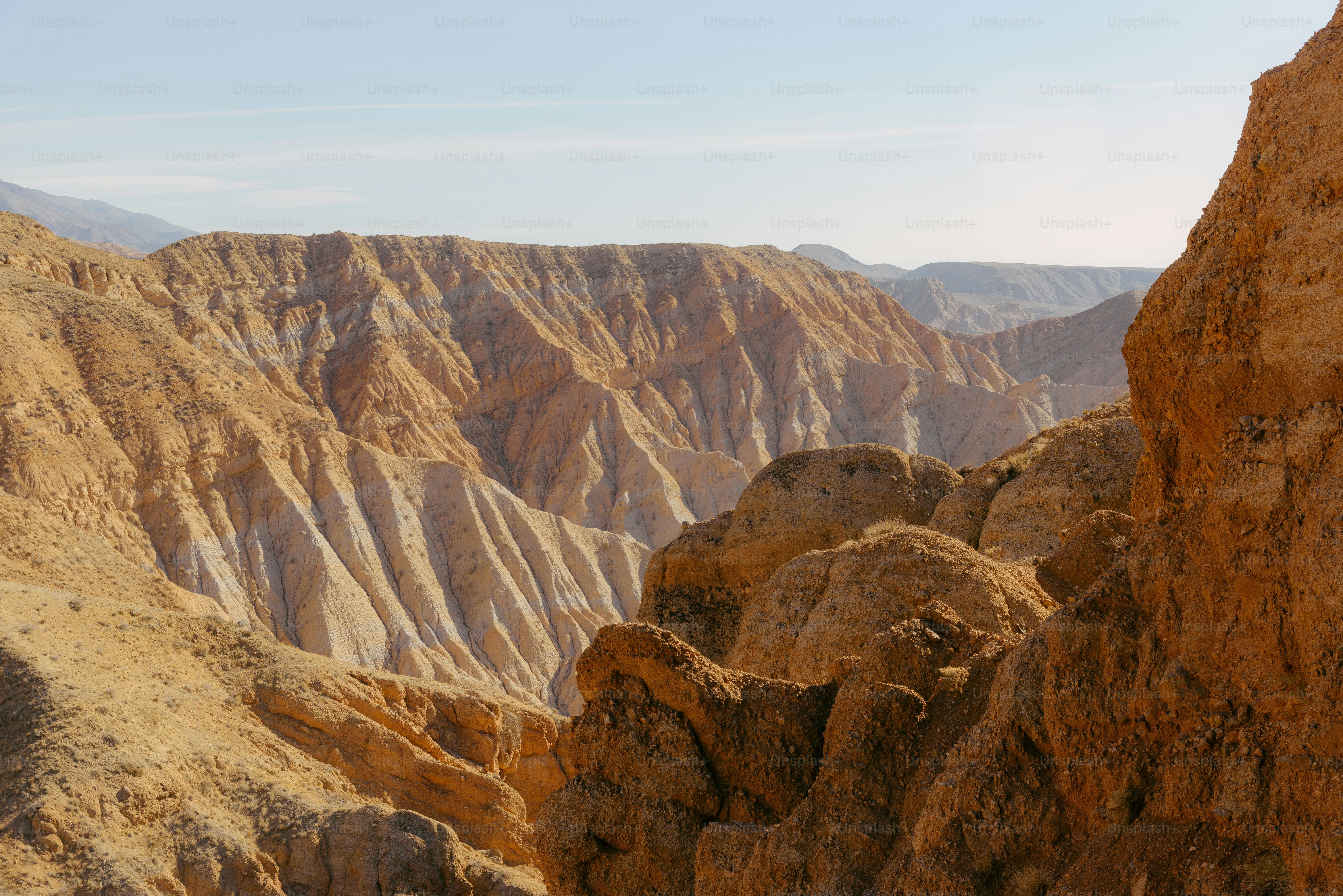 A man standing on top of a mountain next to a cliff