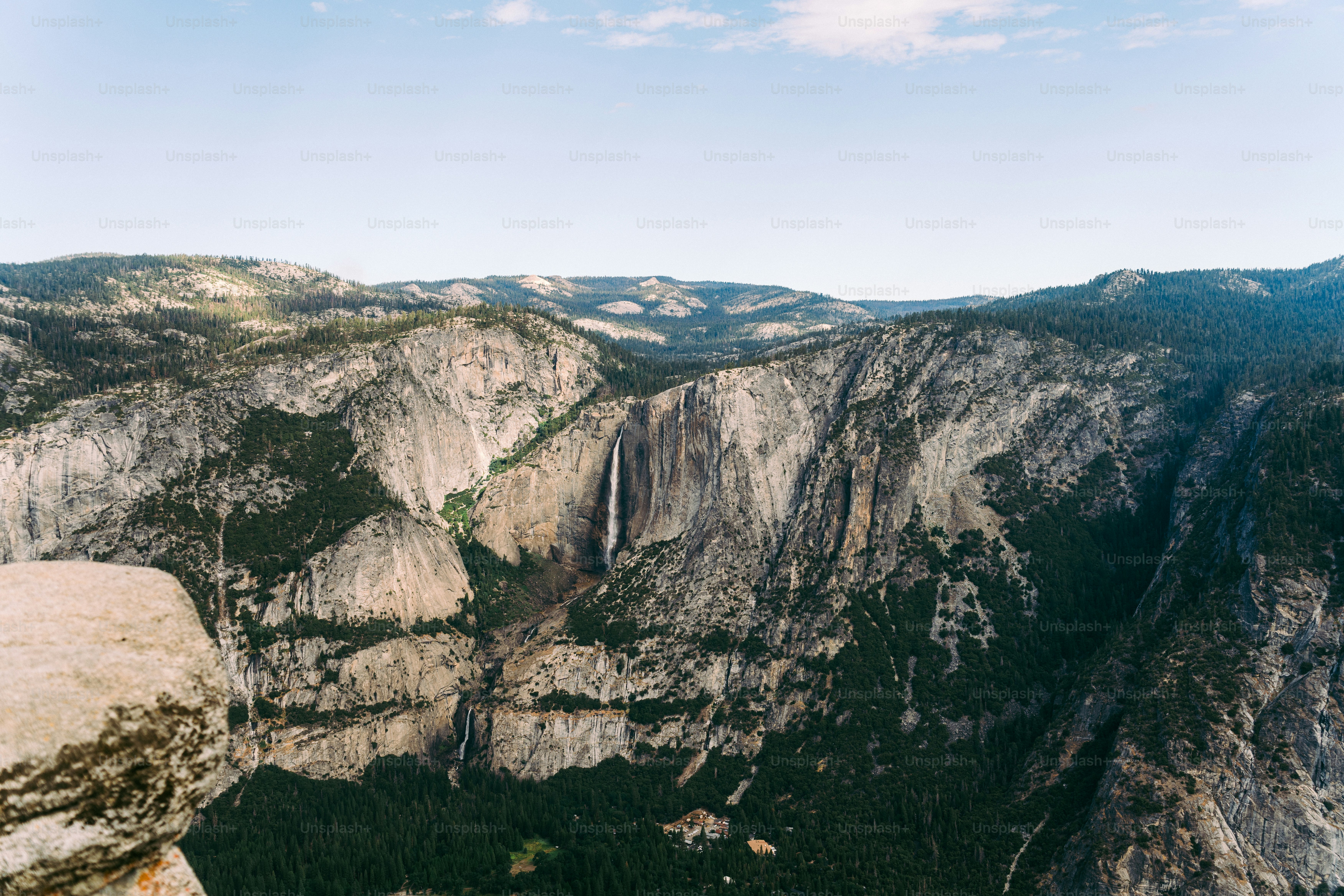 A man standing on top of a mountain next to a cliff