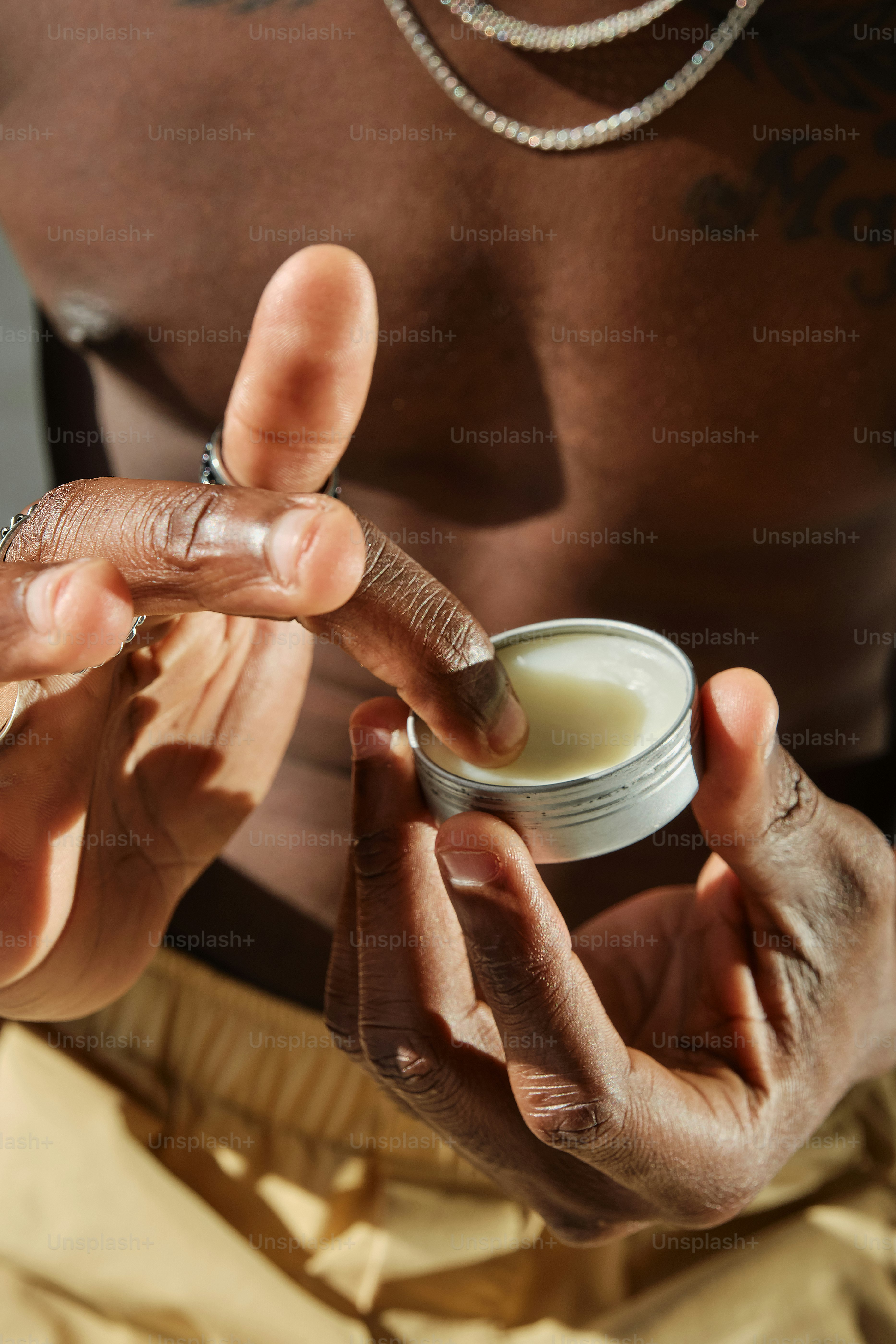 A man holding a container of cream in his hands