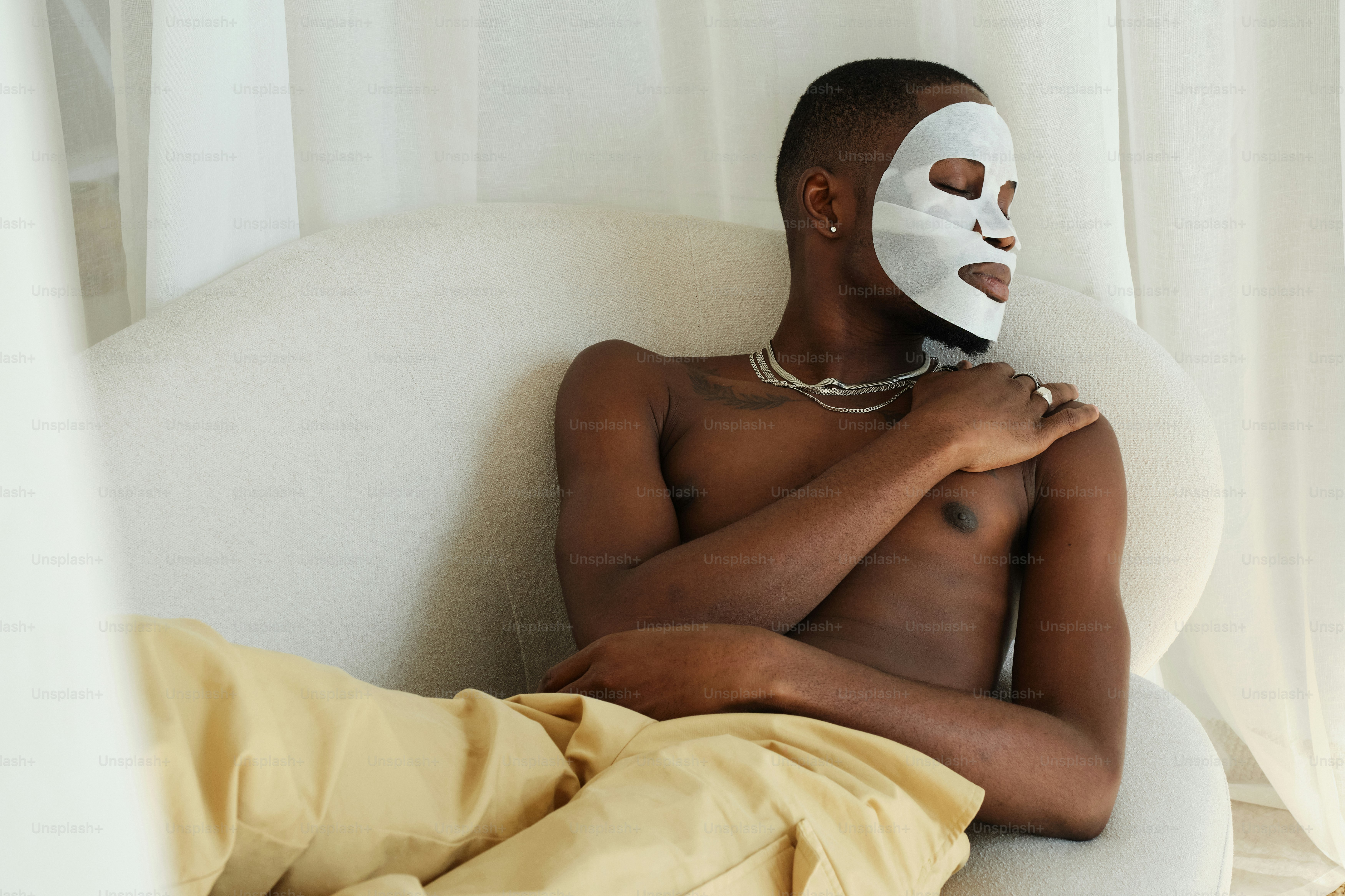A man with a mask on sitting in a chair
