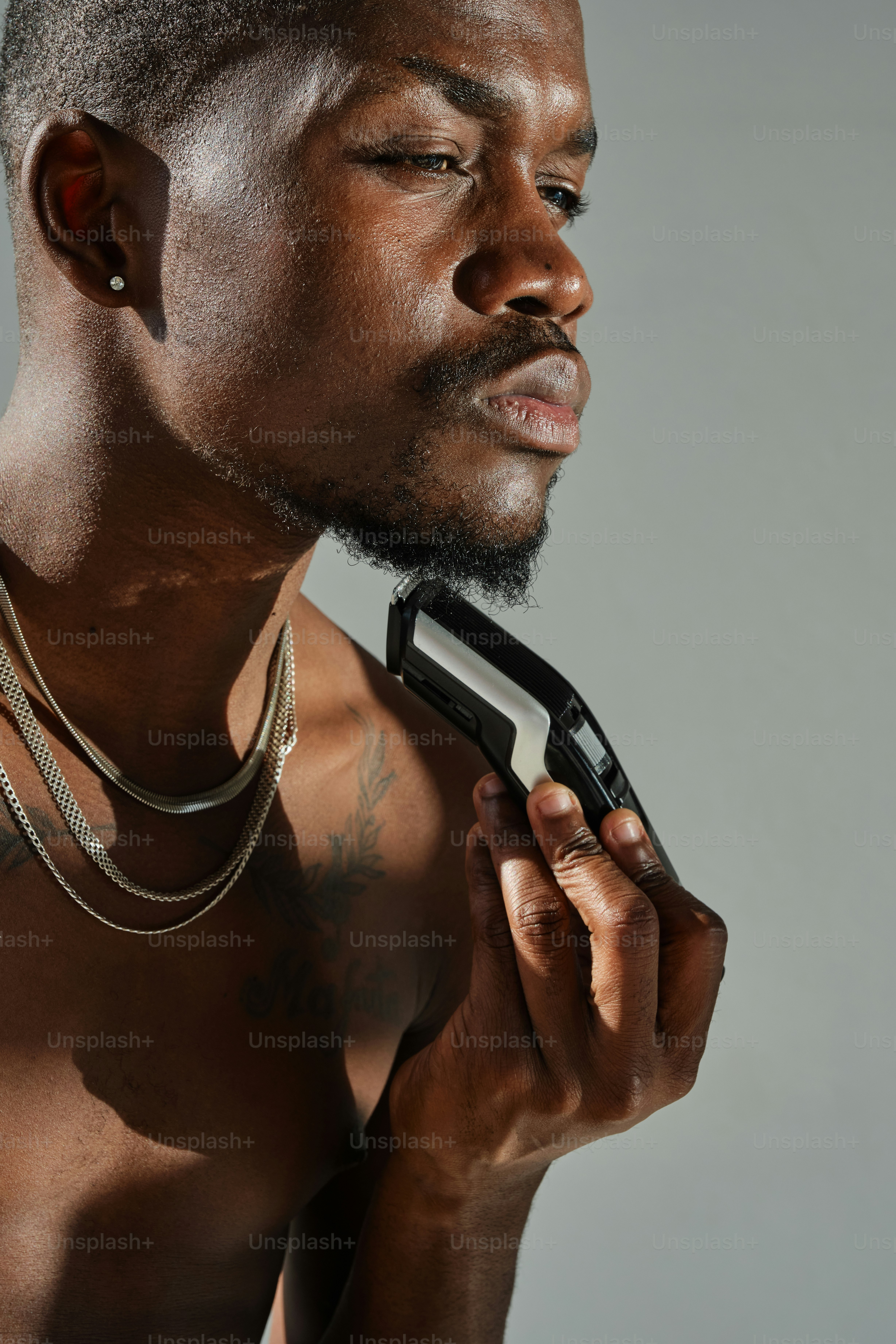 A shirtless man holding a pair of scissors