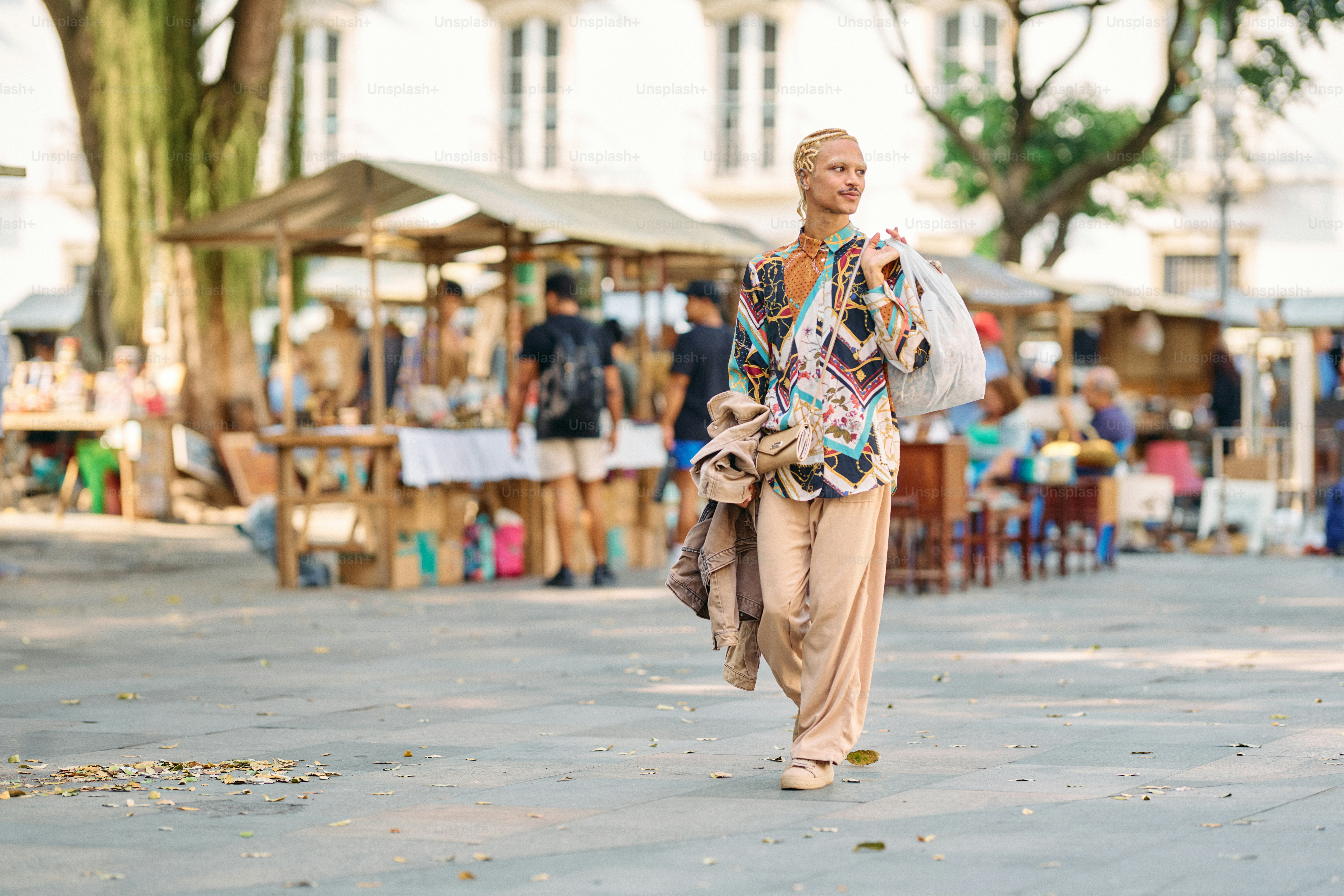A woman walking down a street next to a crowd of people