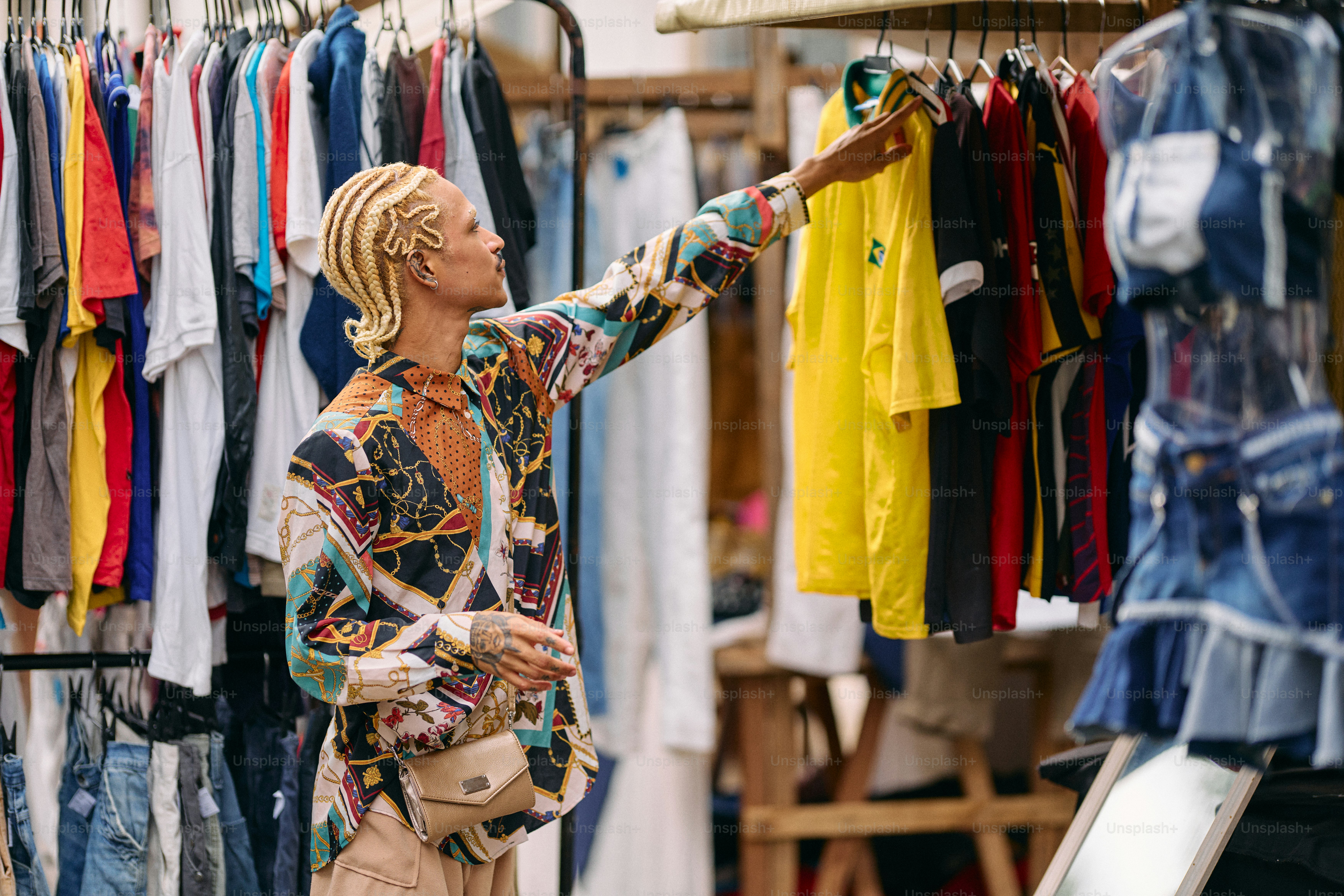A person holding onto a rack of clothes photo – Shopping spree Image on ...