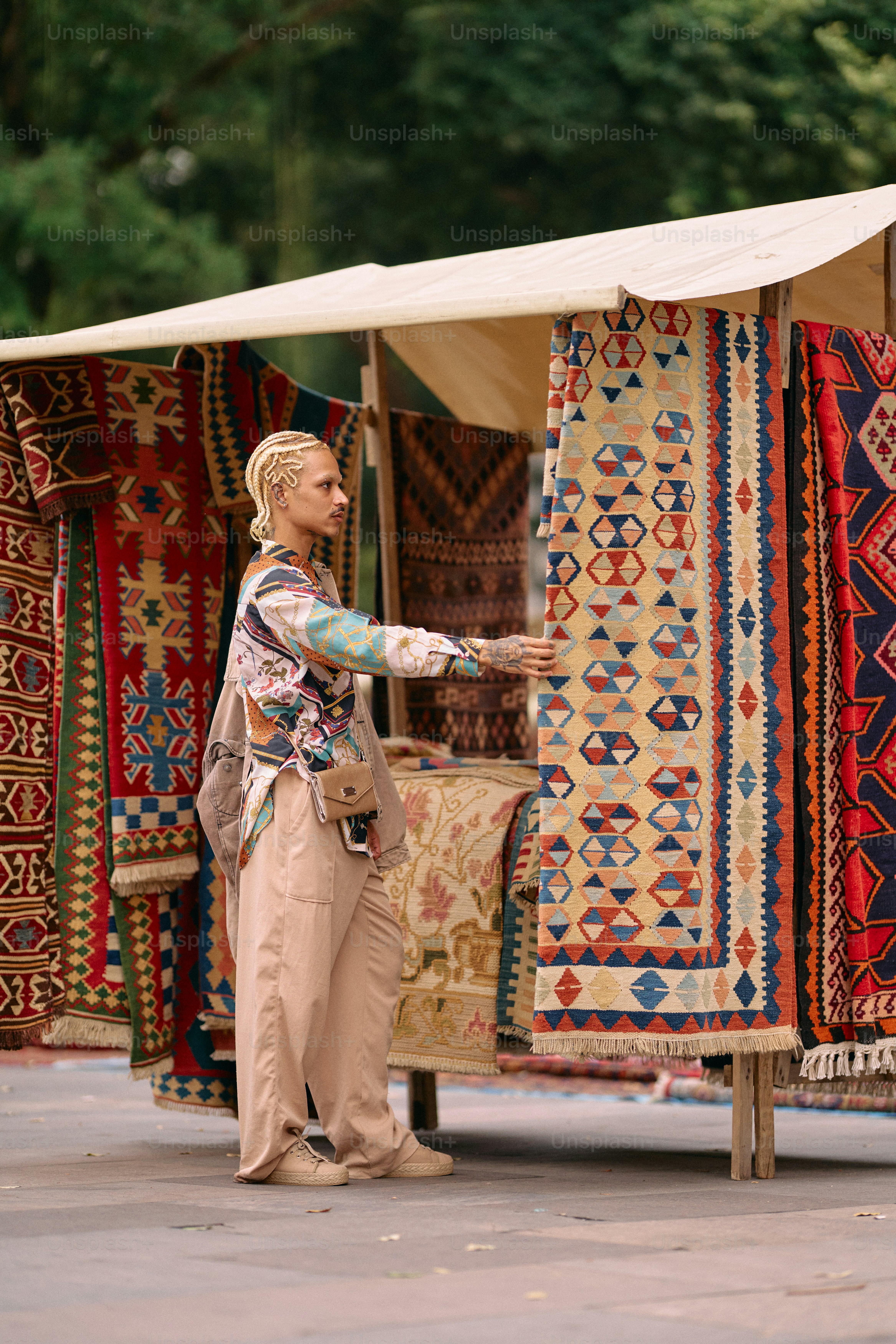 A woman standing in front of a display of rugs photo – Portrait Image ...