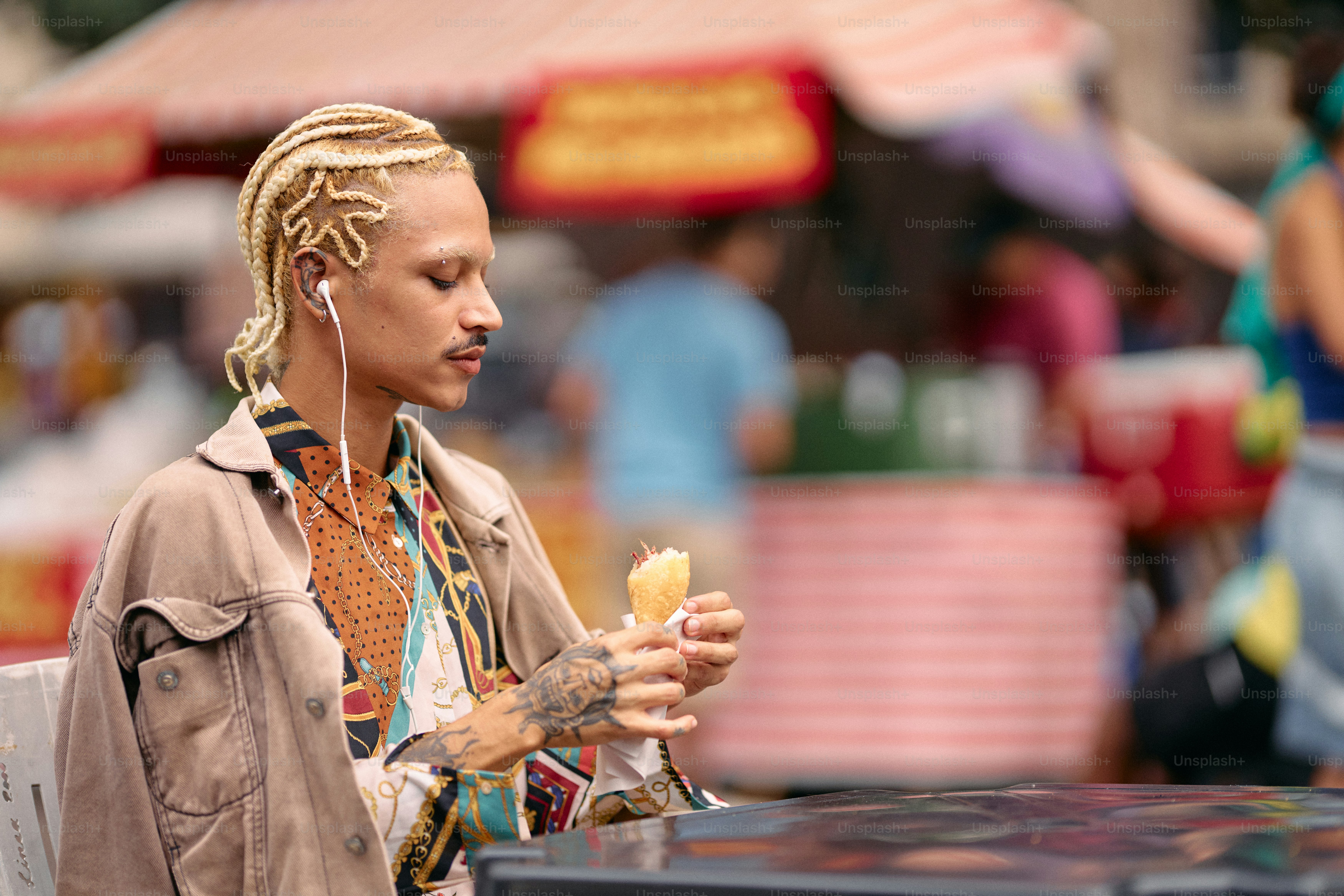 A man with dreadlocks eating an ice cream cone