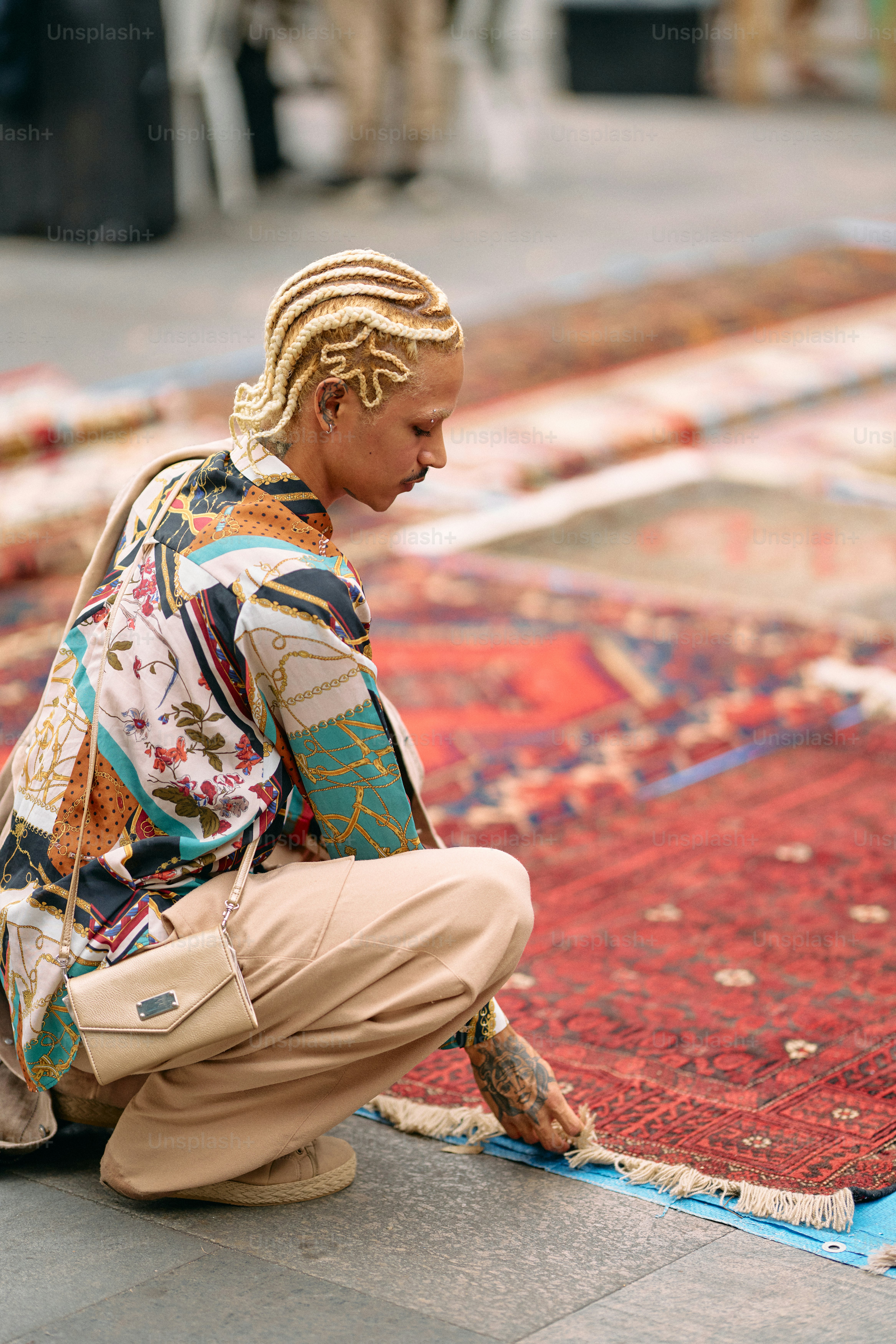 A woman kneeling down on a rug on the ground
