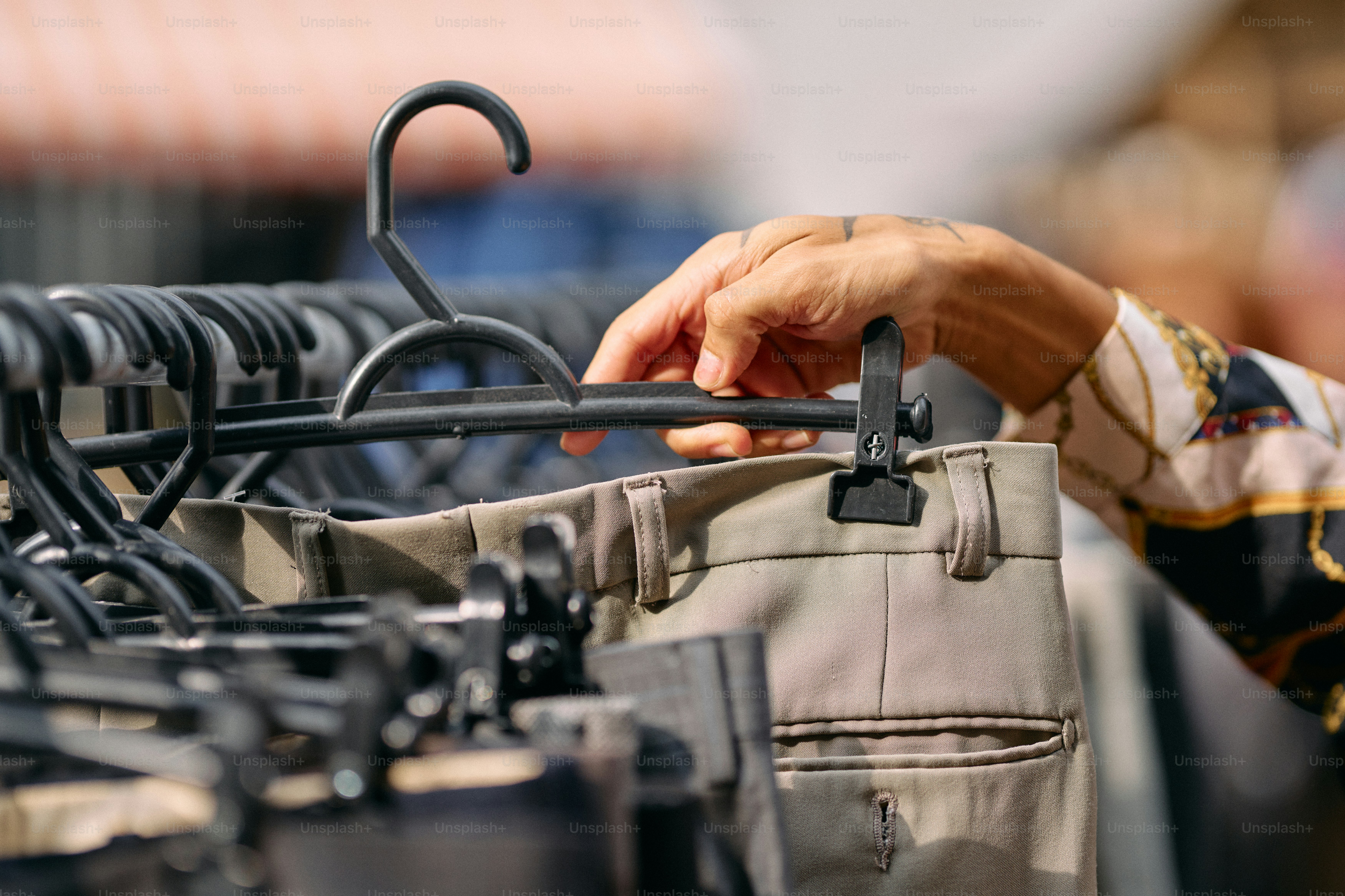 A person holding onto a rack of clothes