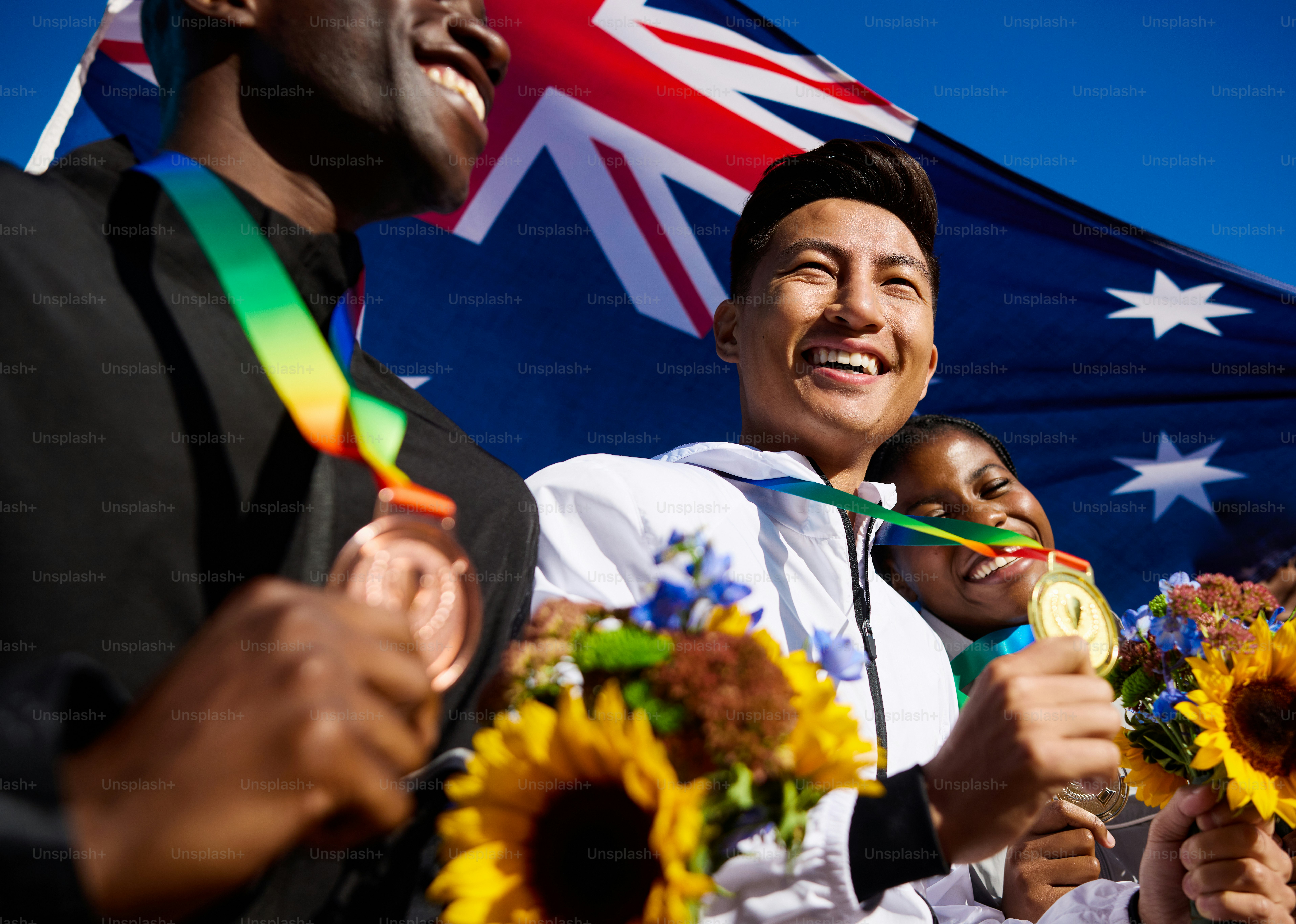 Ecstatic Australian athletes with medals and bouquets against the ...