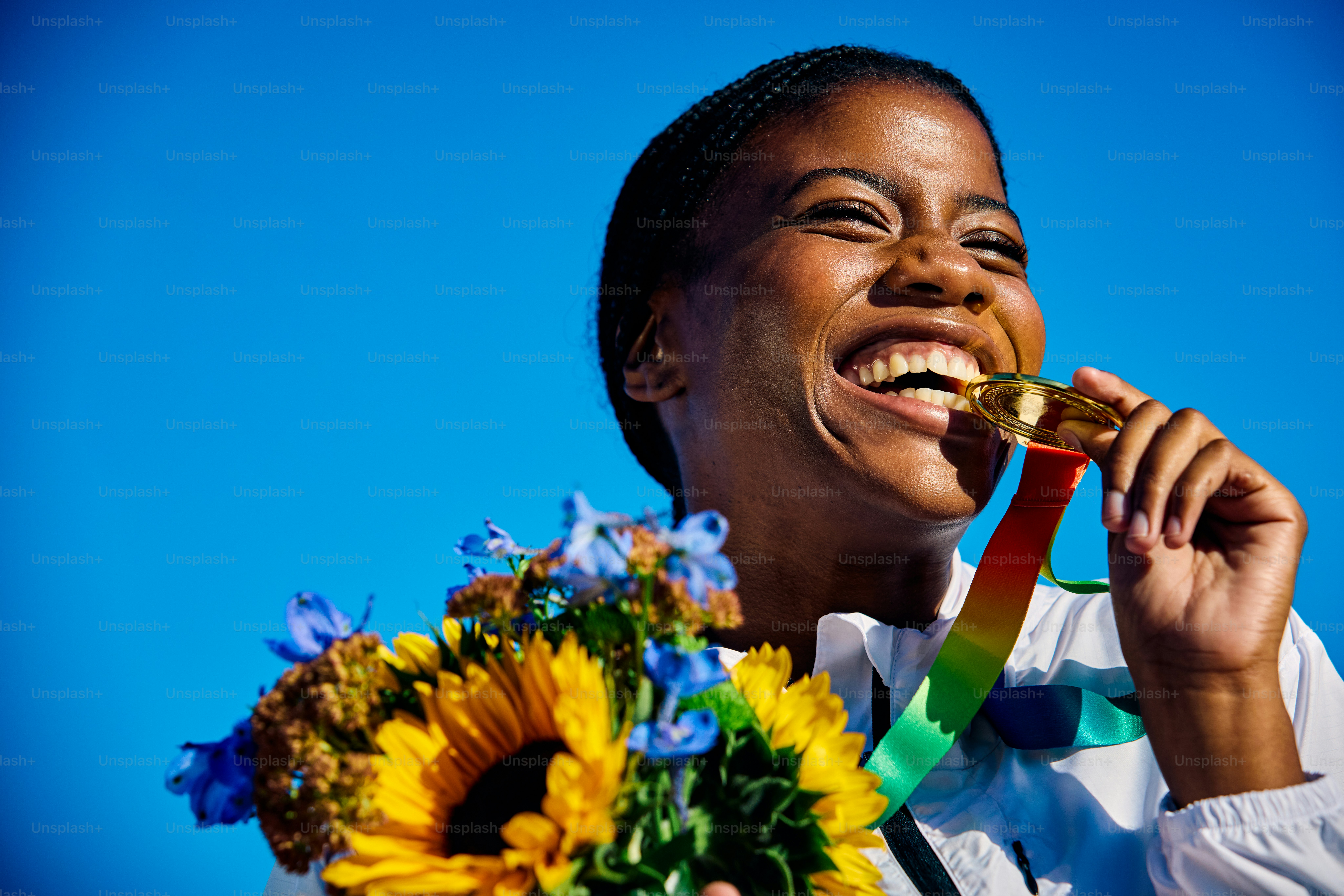 Atleta internacional sosteniendo medalla con ramo de flores. Retrato al aire libre con fondo arquitectónico. Reflexión sobre el concepto de éxito