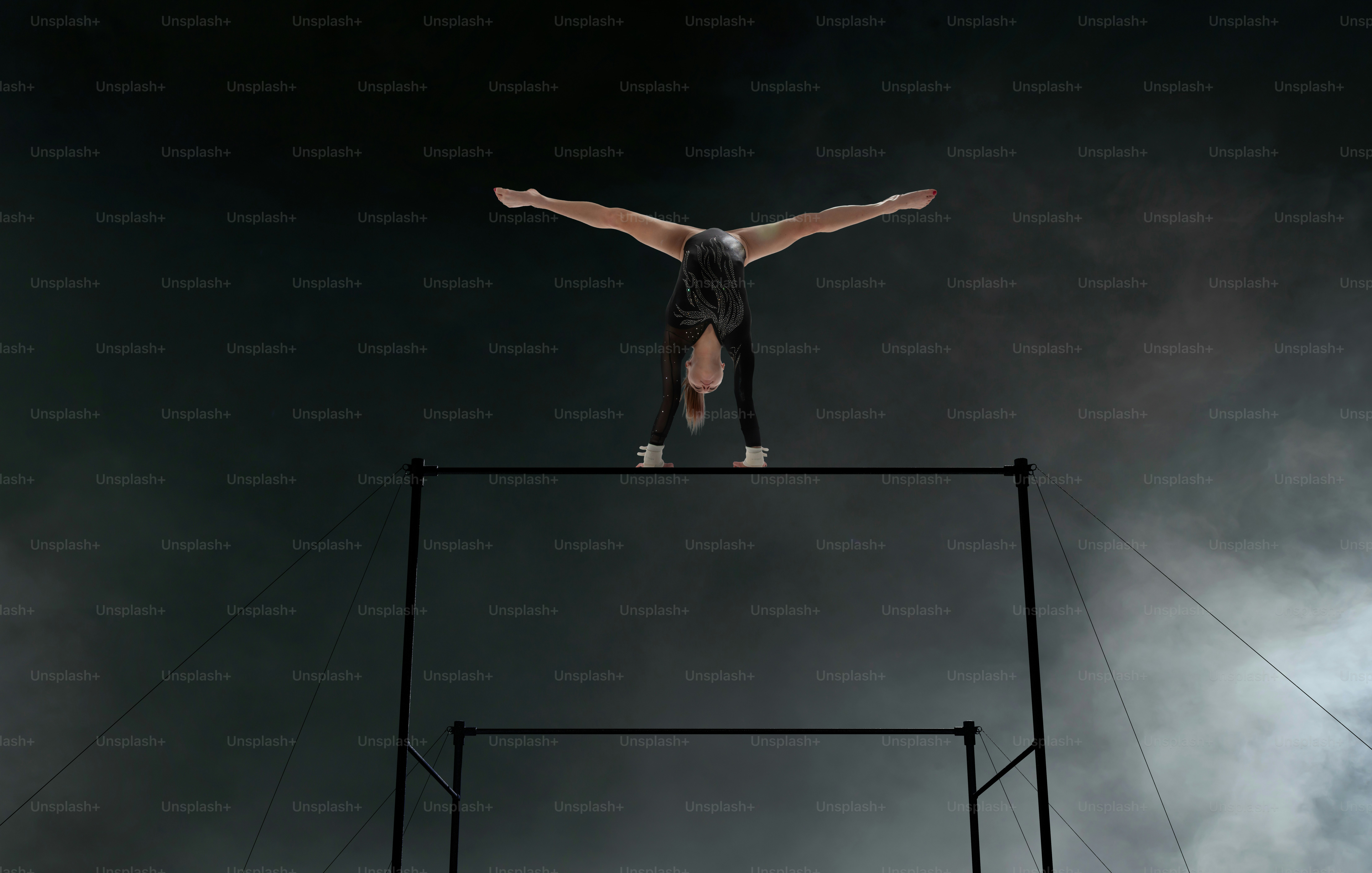 Female gymnast doing a complicated trick in a professional arena.