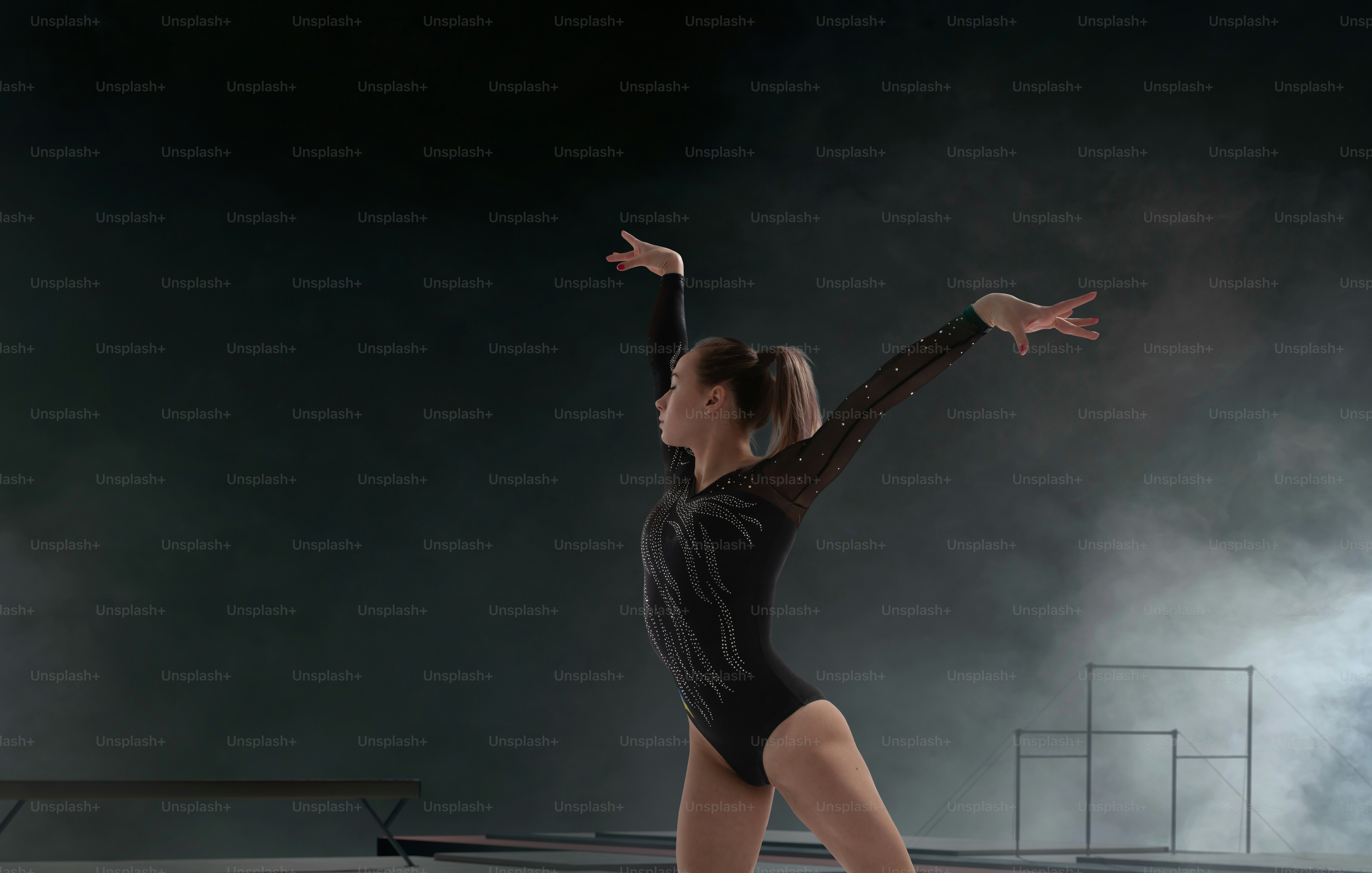 Female gymnast doing a complicated trick in a professional arena.