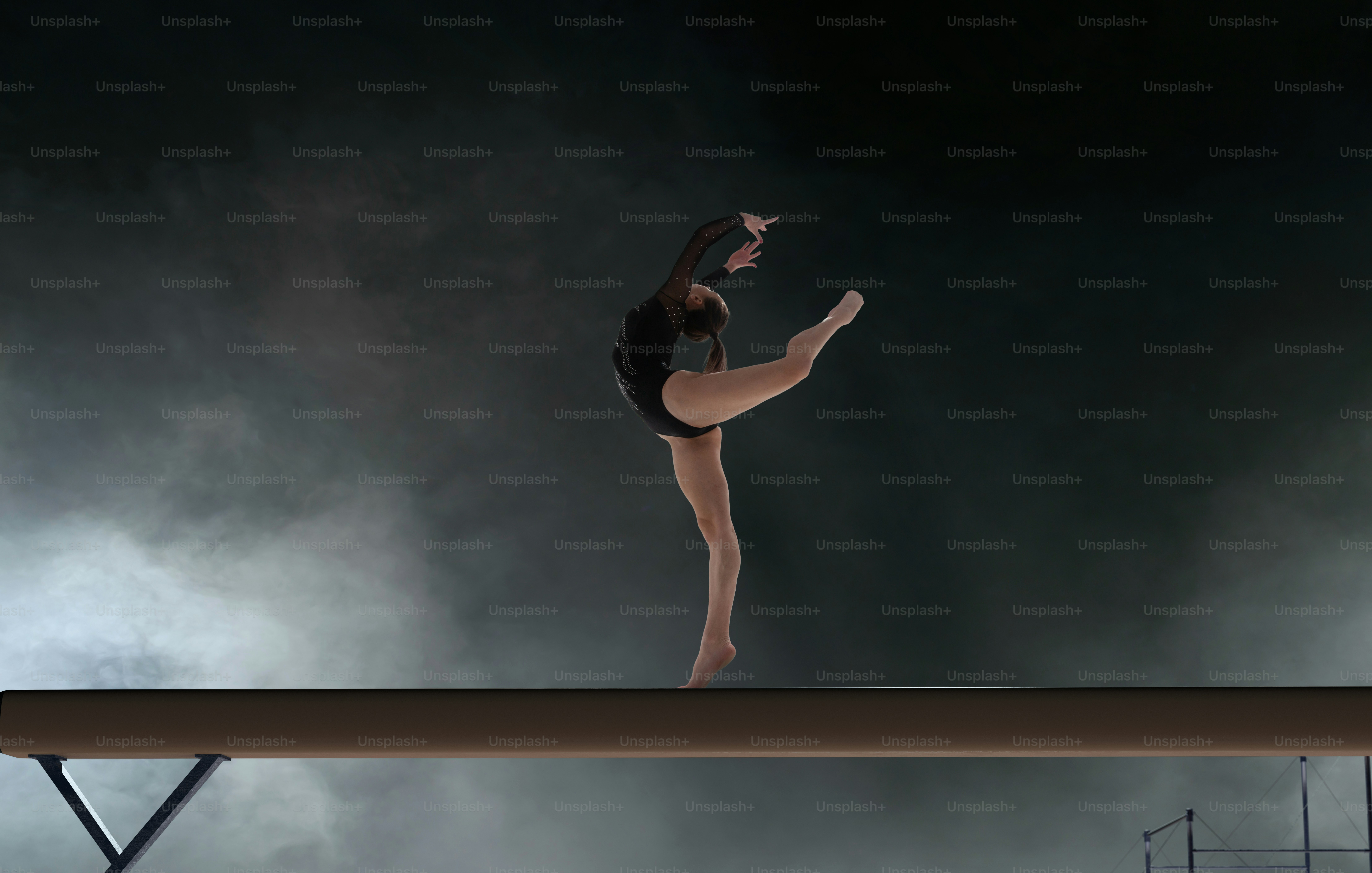 Female gymnast doing a complicated trick in a professional arena.