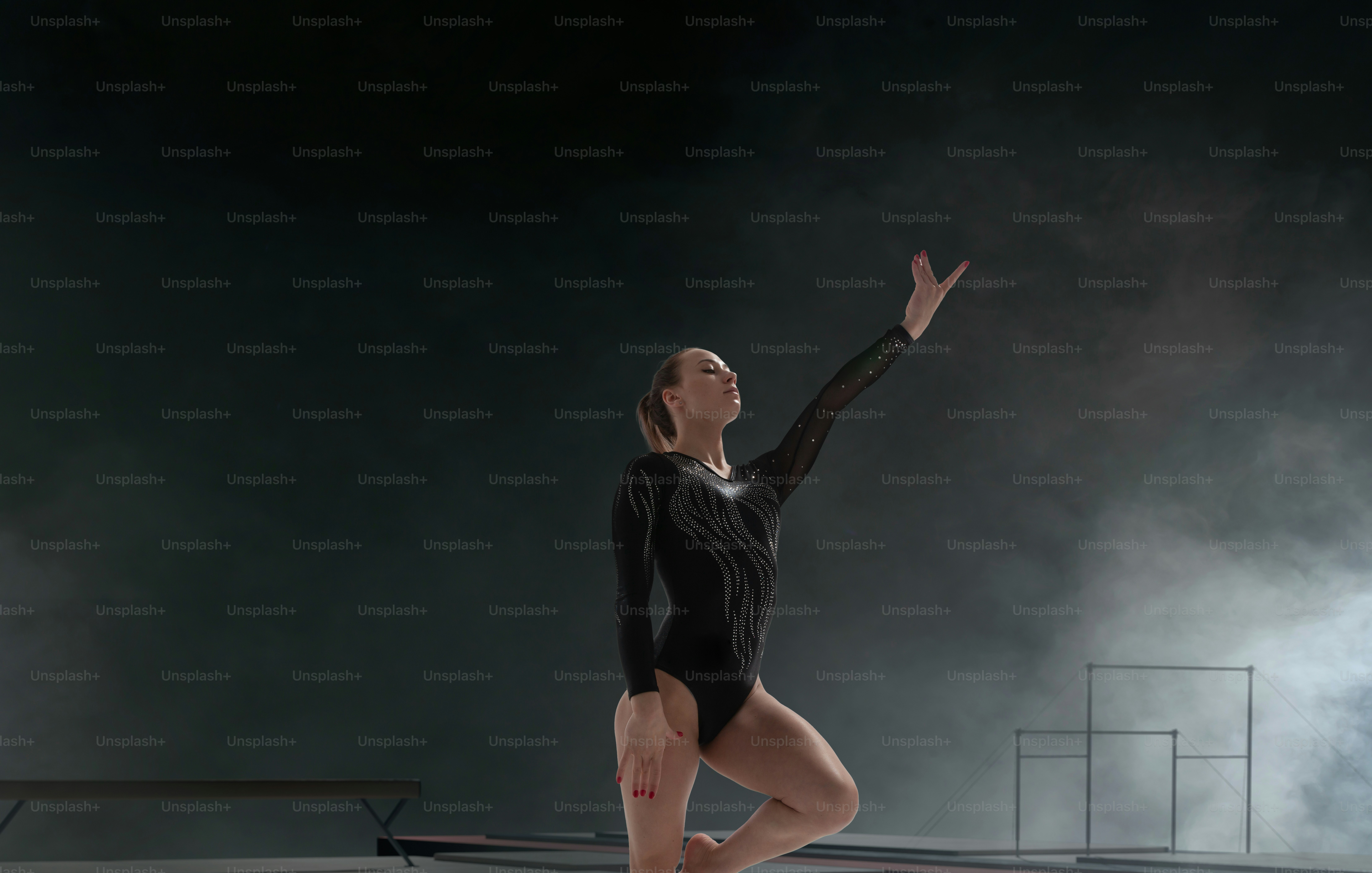 Female gymnast doing a complicated trick in a professional arena.