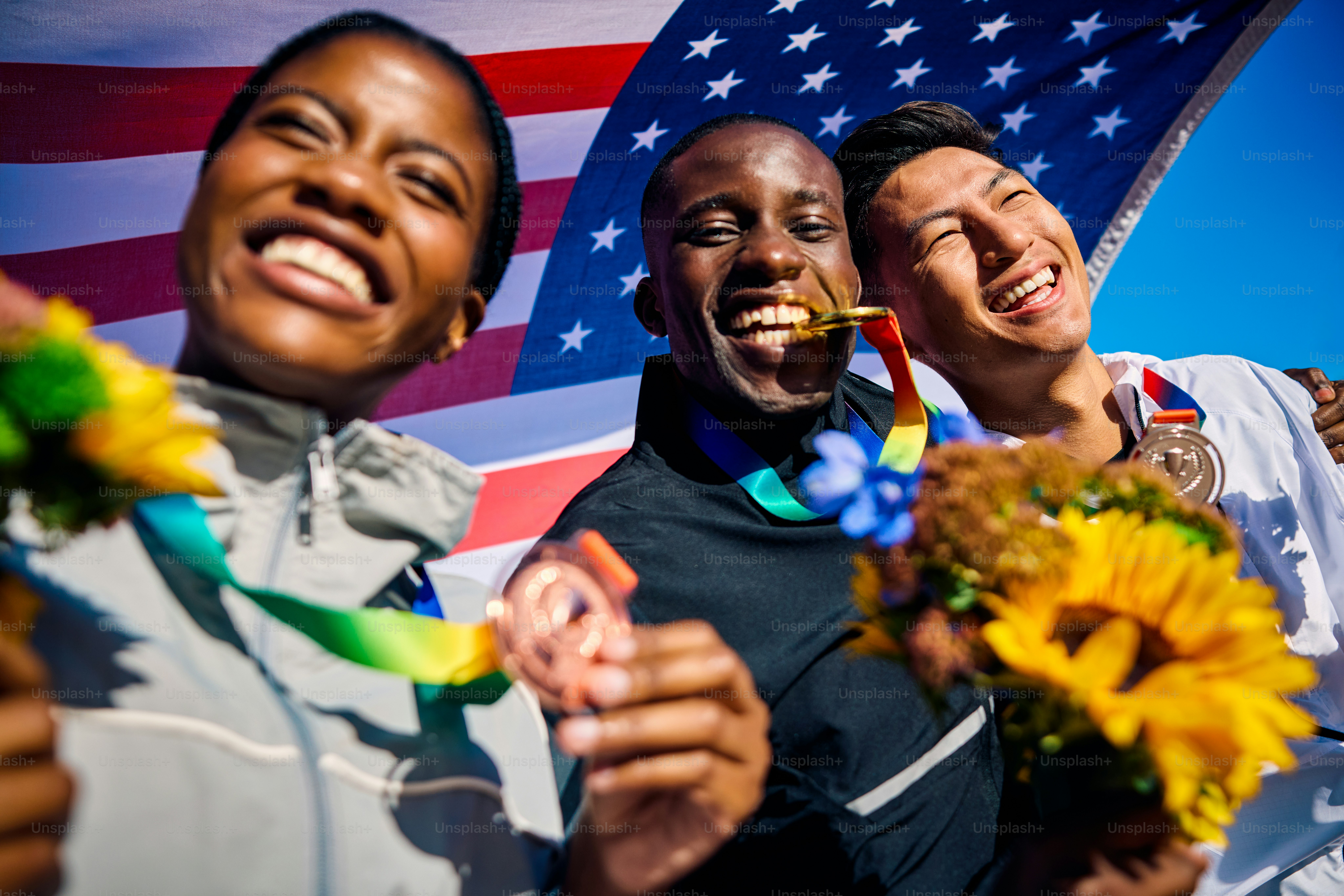 Ecstatic Team USA athletes with medals and bouquets against the ...