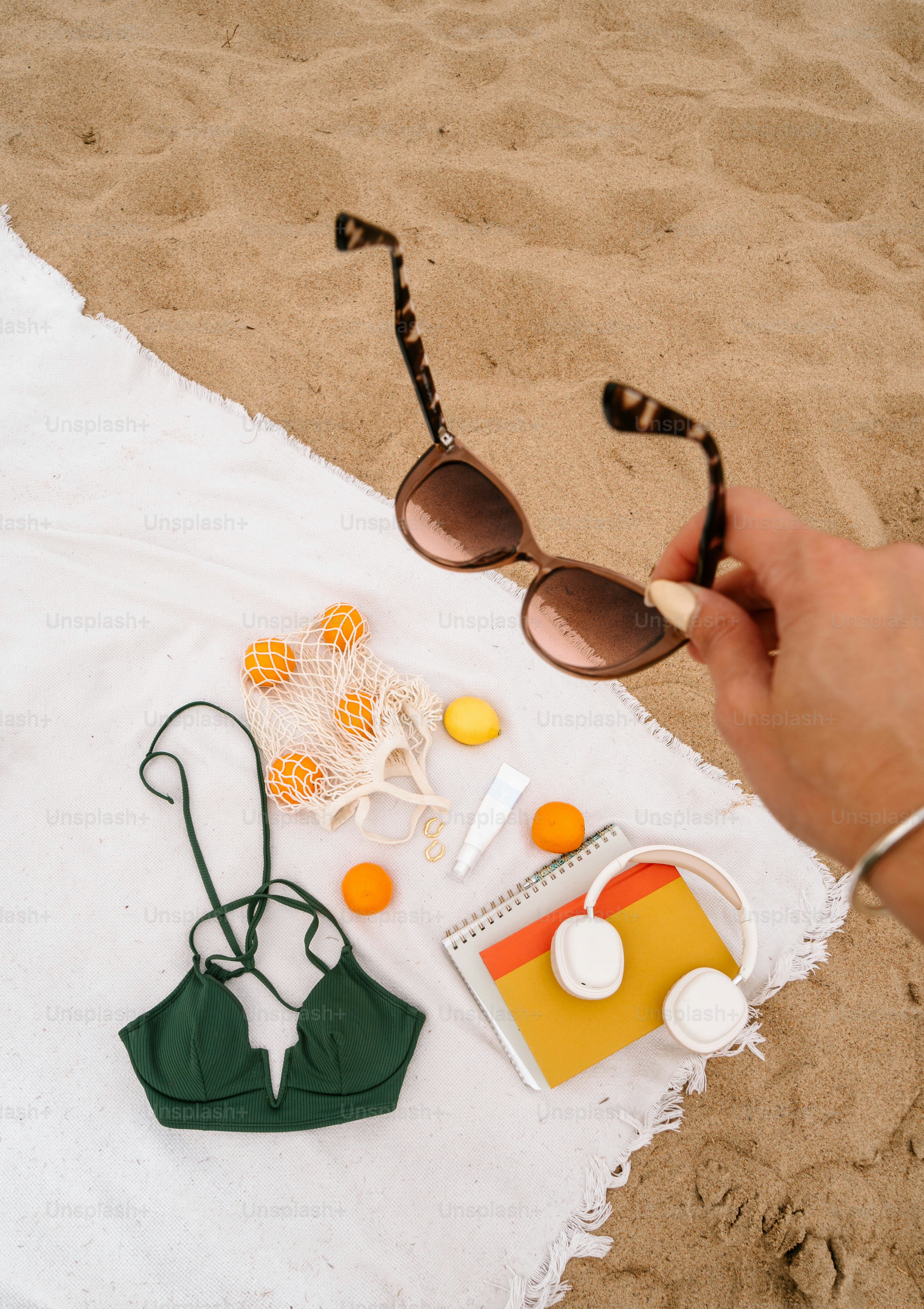 Une personne tenant une paire de lunettes de soleil sur une serviette