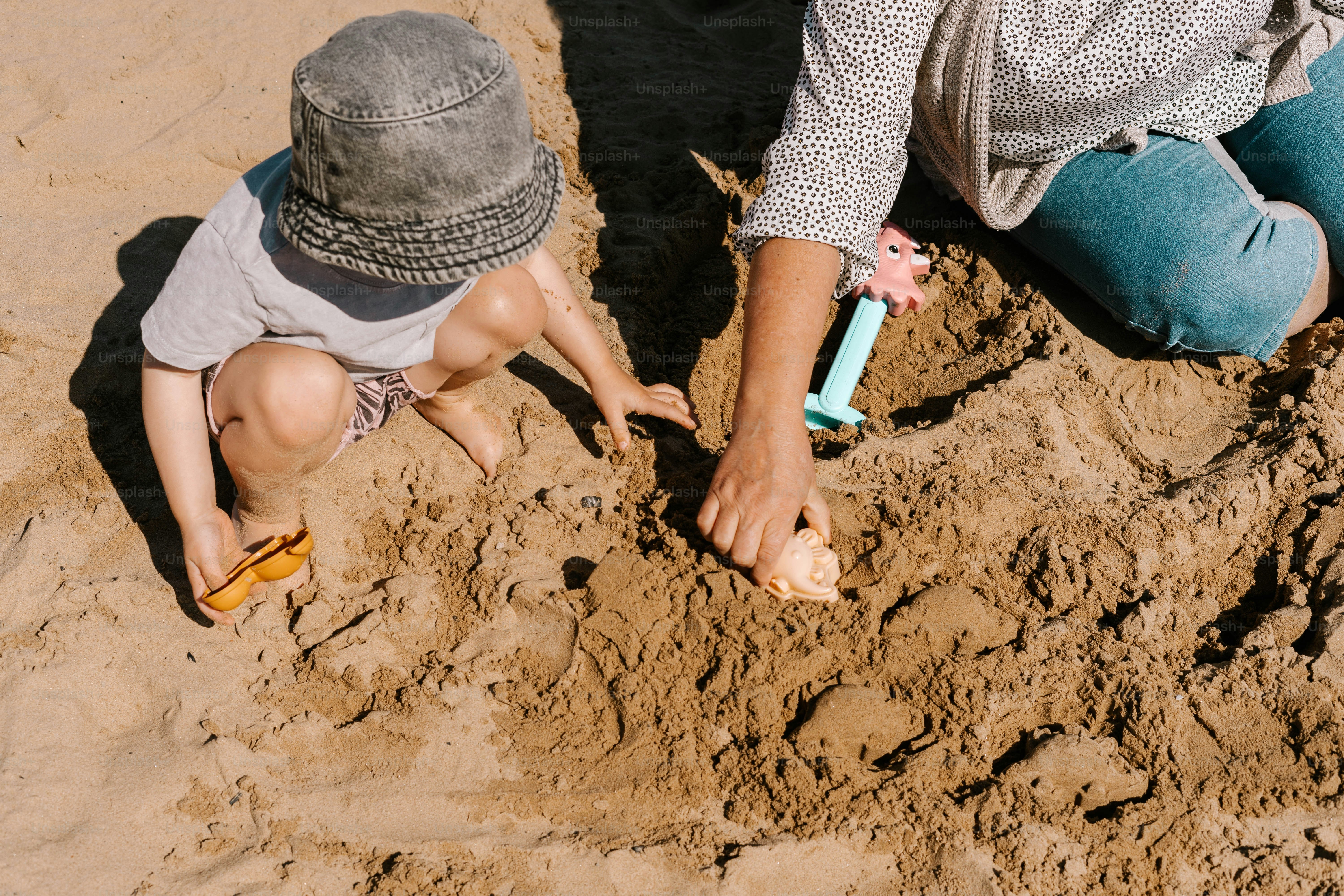 A woman and a child playing in the sand