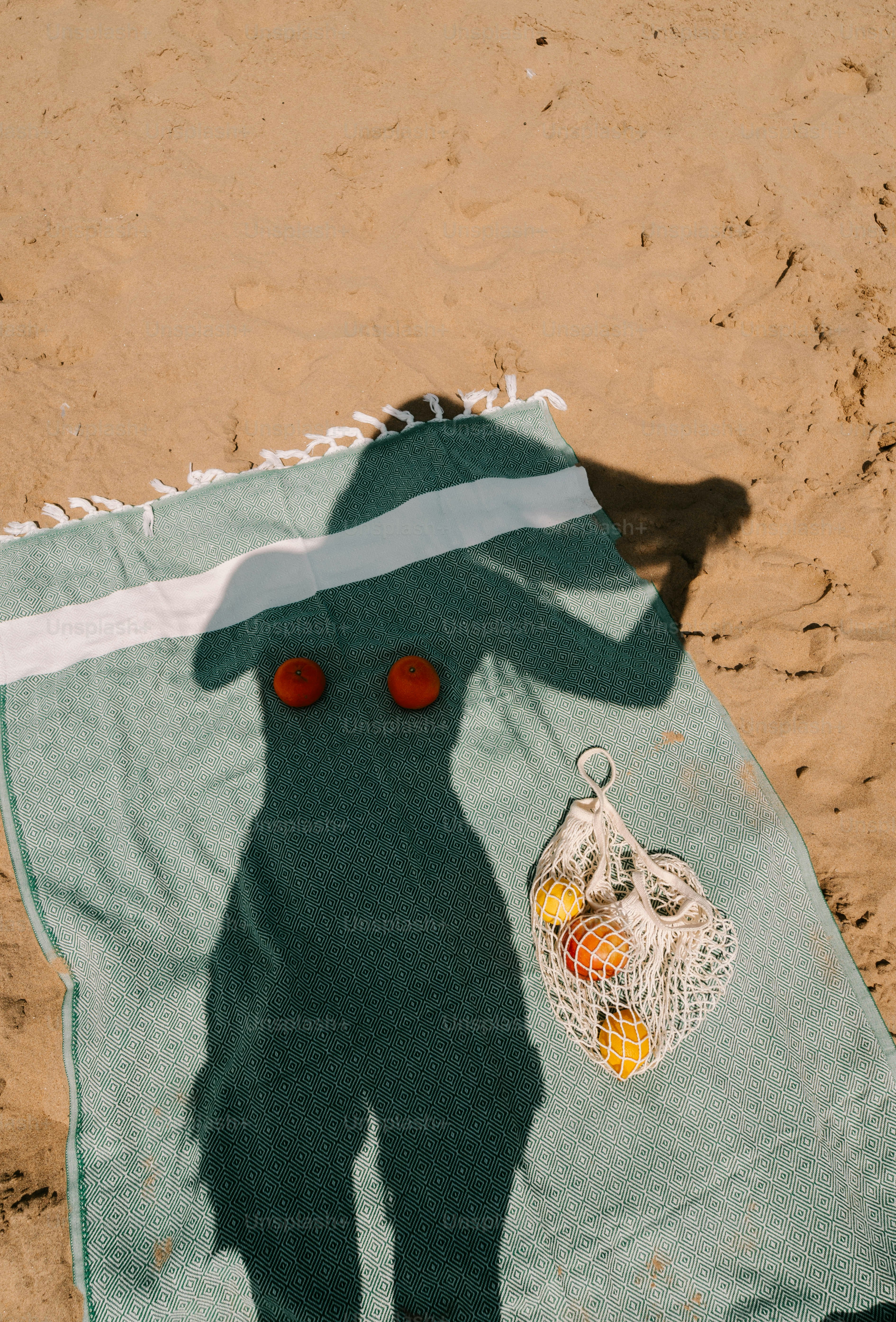 A towel laying on top of a sandy beach