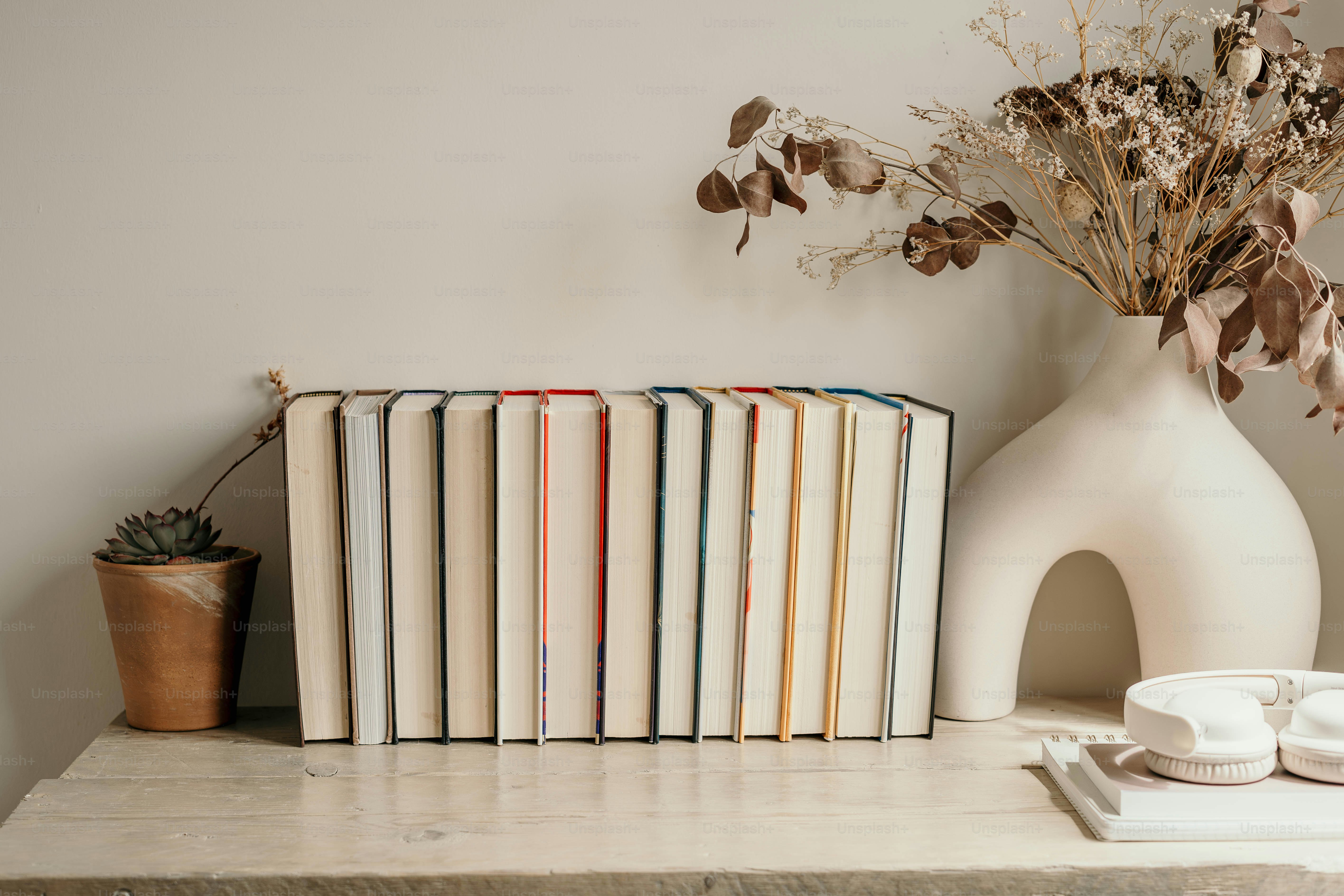 A table topped with books and a vase filled with flowers