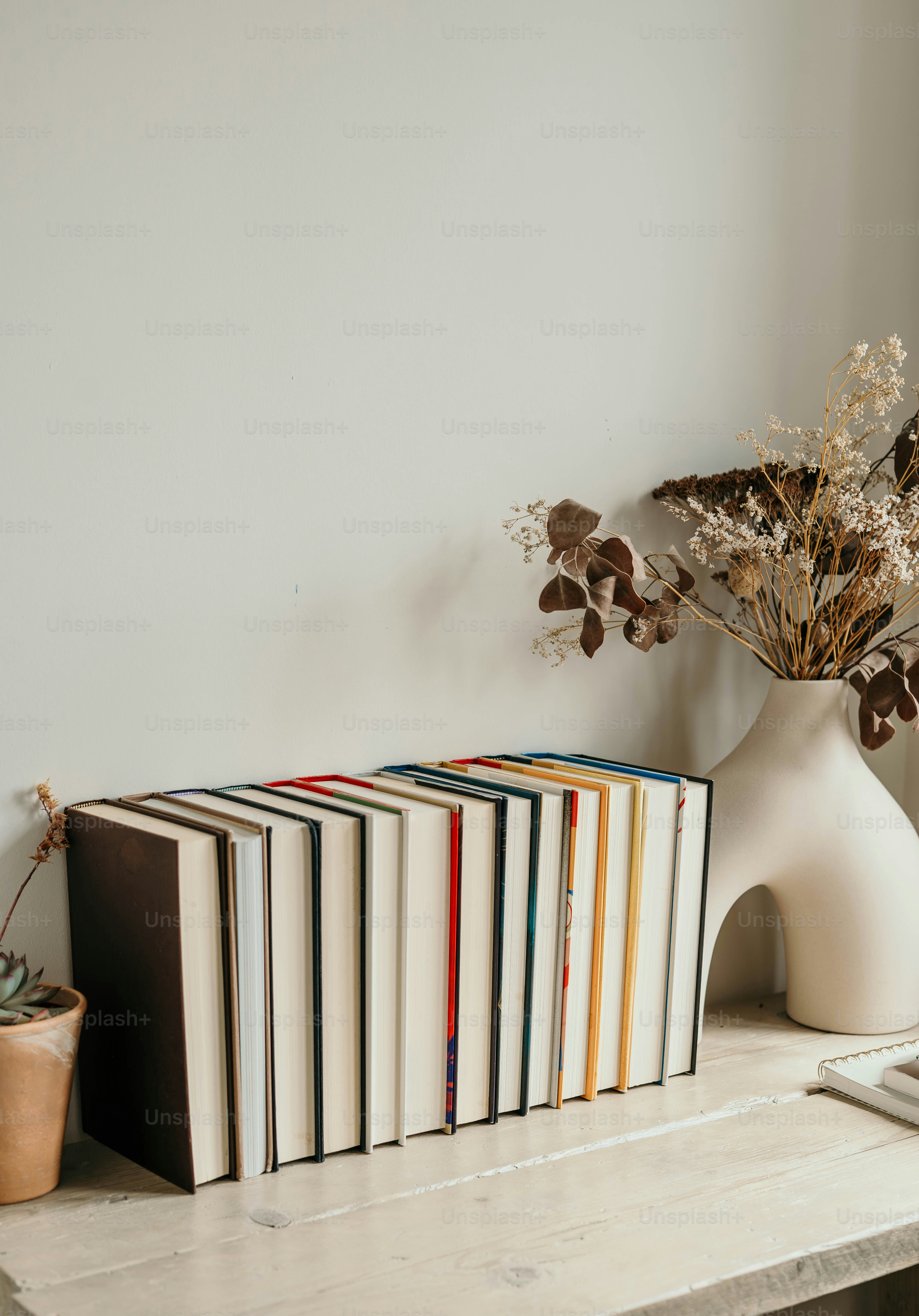 A table topped with books and a vase filled with flowers