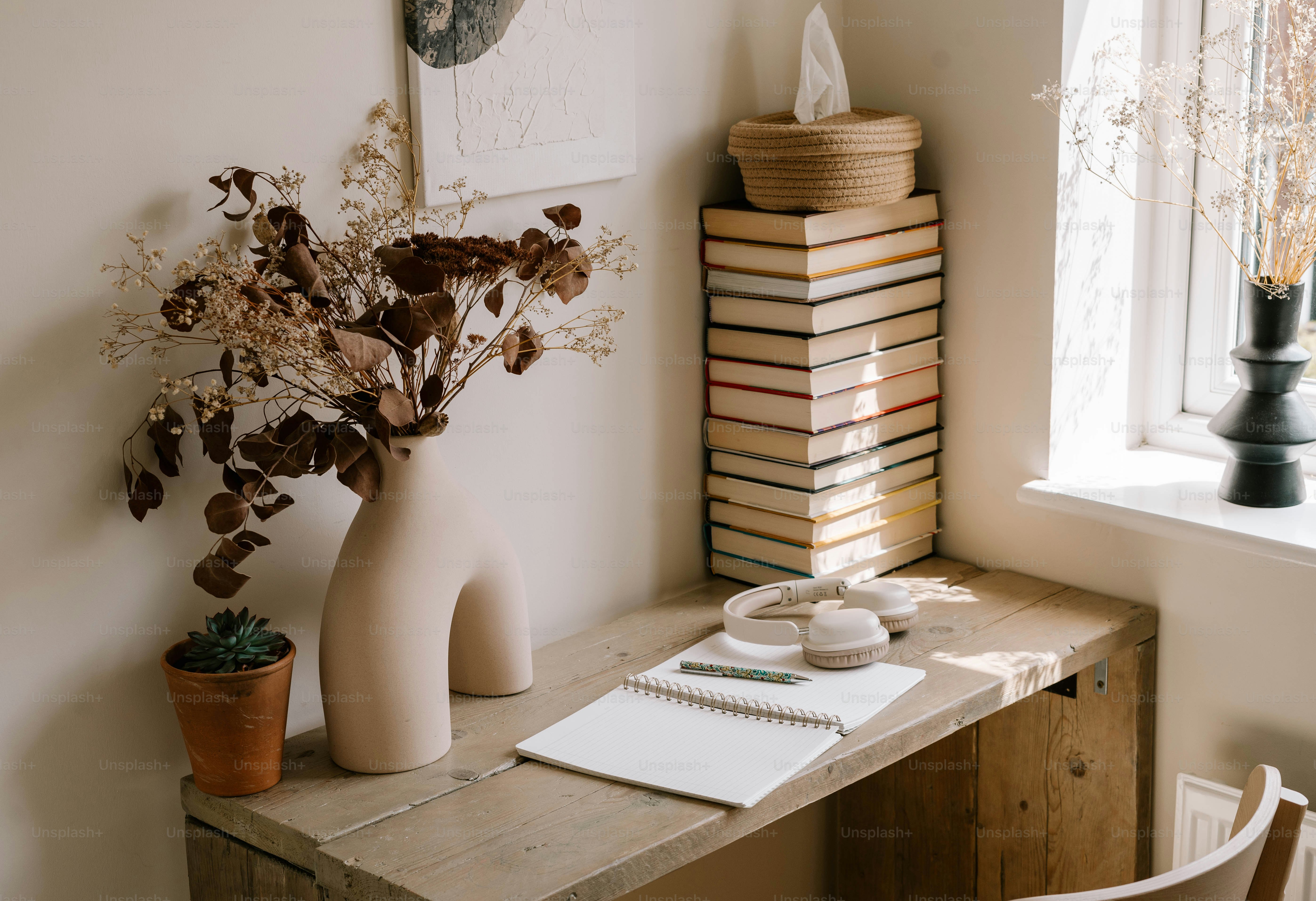A wooden desk with a vase of flowers on top of it