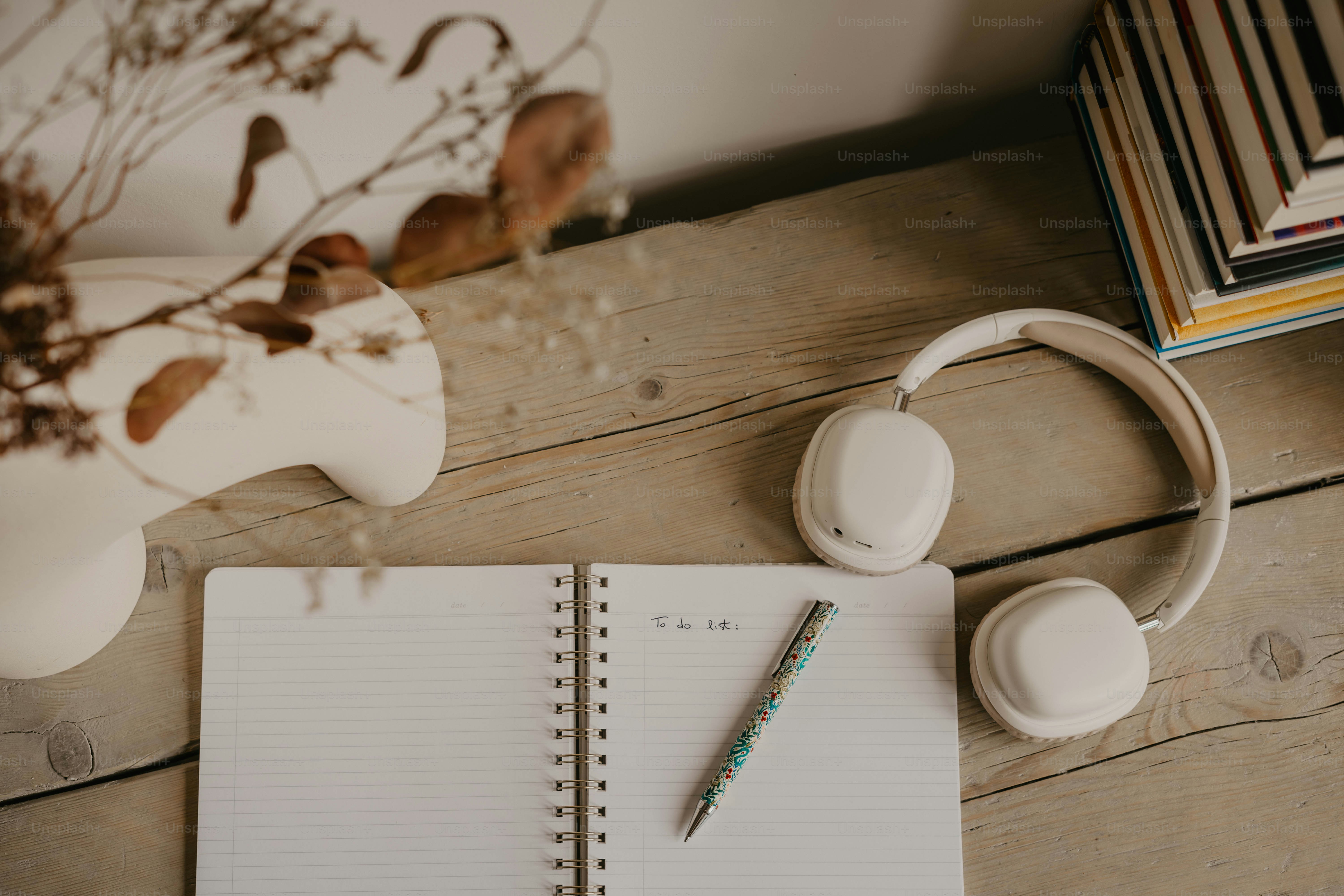 Un taccuino, le cuffie e una pianta su un tavolo