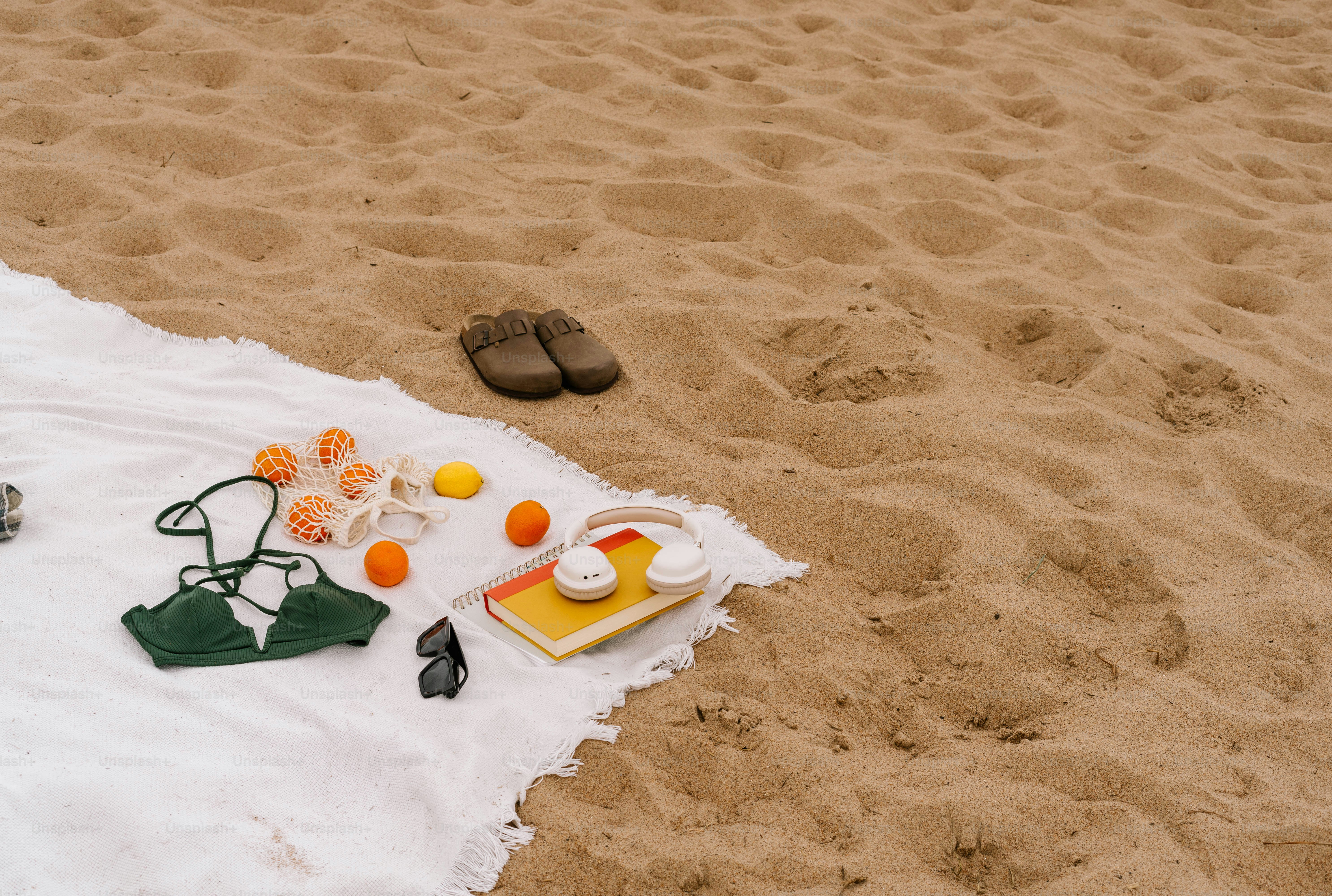 A towel on a beach with a picnic set up on it