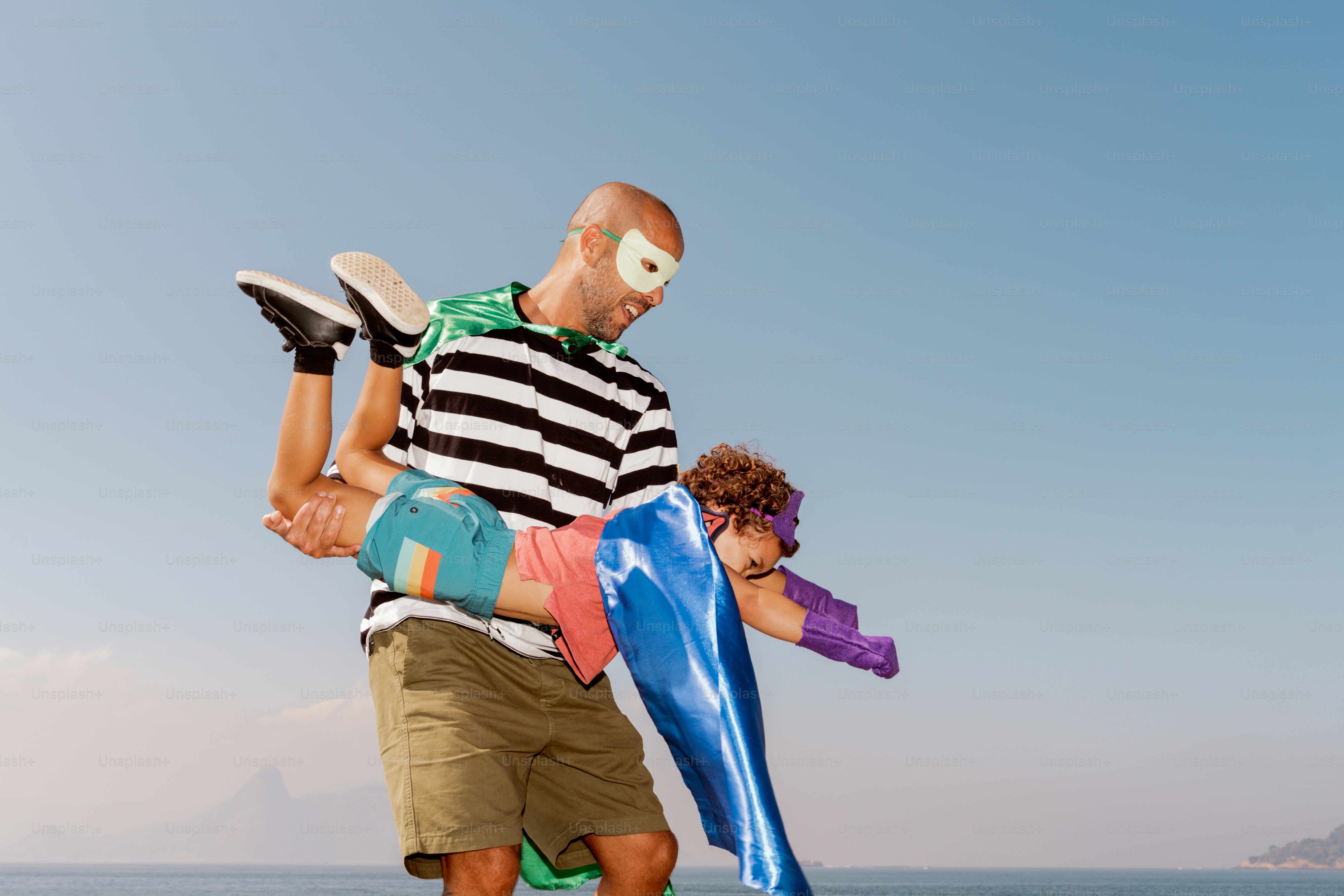 A man carrying a child on his back on the beach