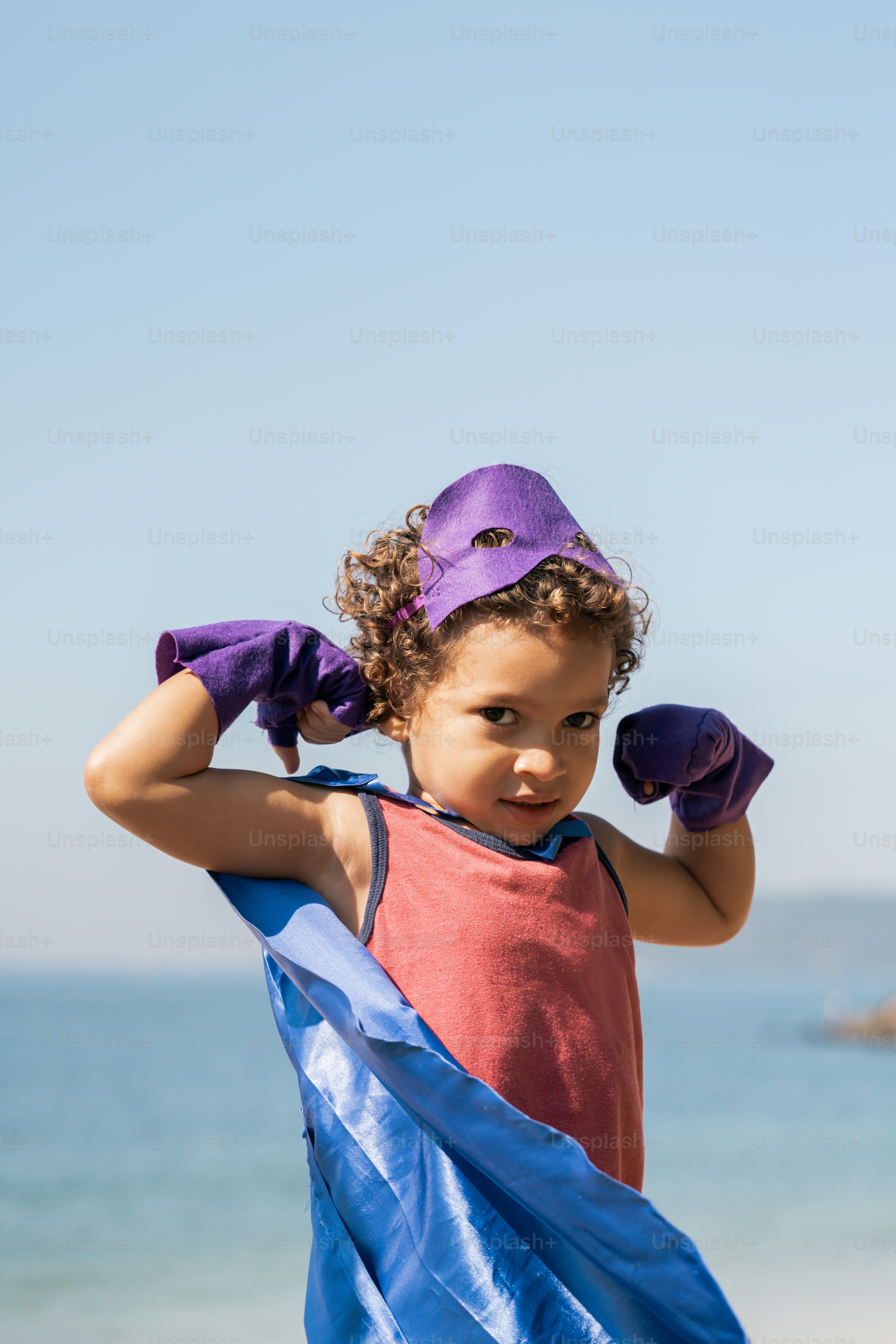 A little girl holding a blue and purple flag