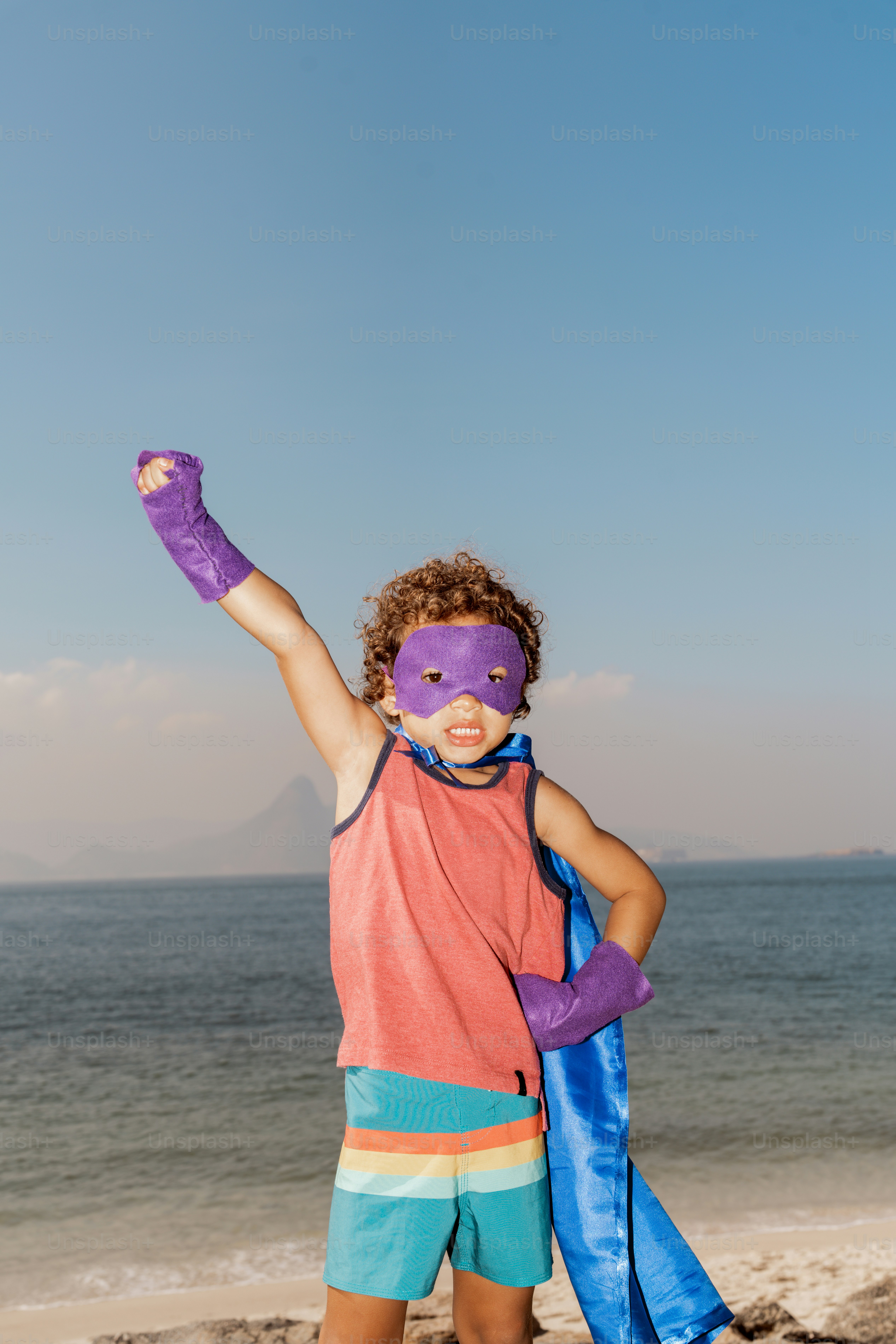 A young boy wearing a purple mask and purple gloves