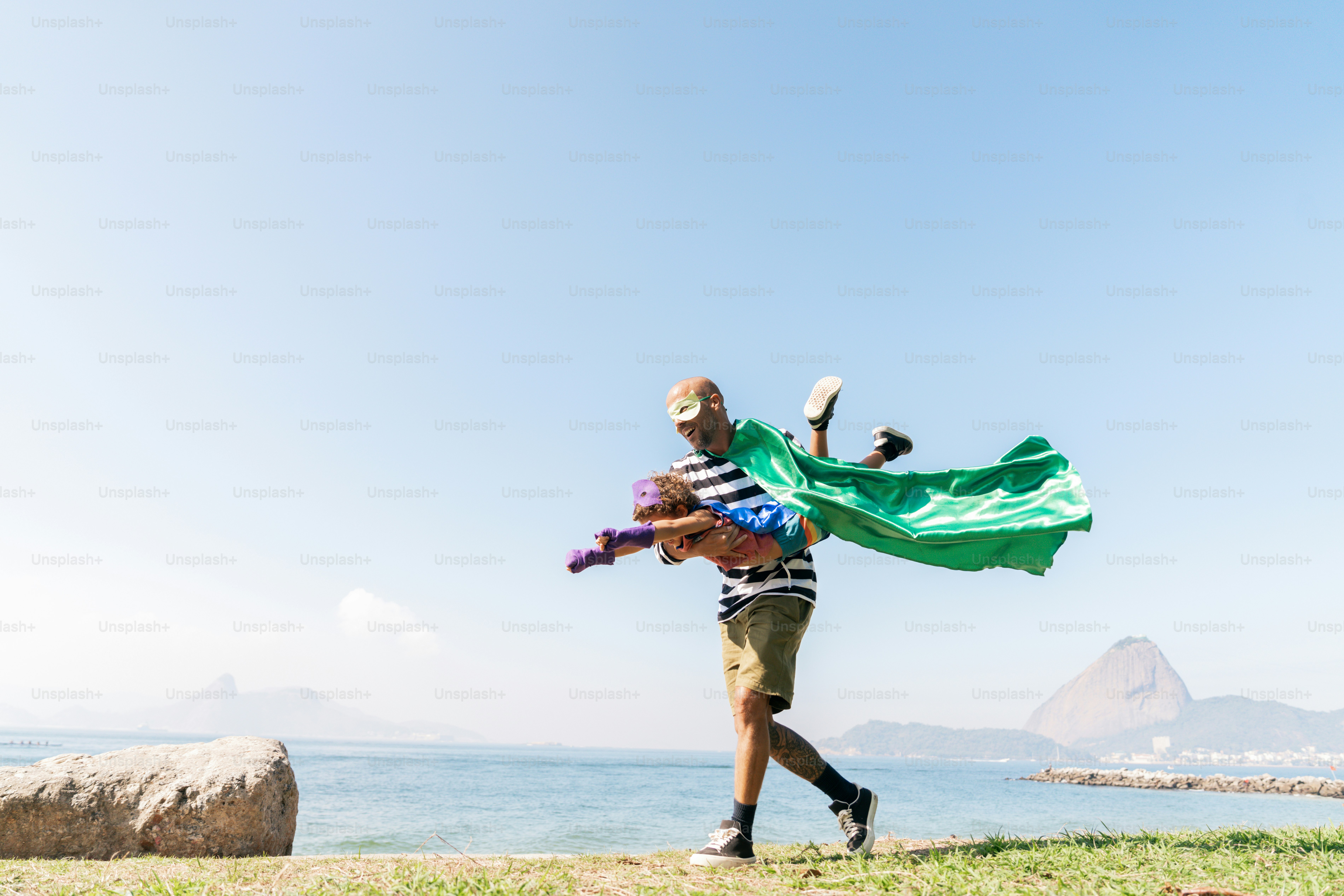 A man holding a green flag walking on a beach