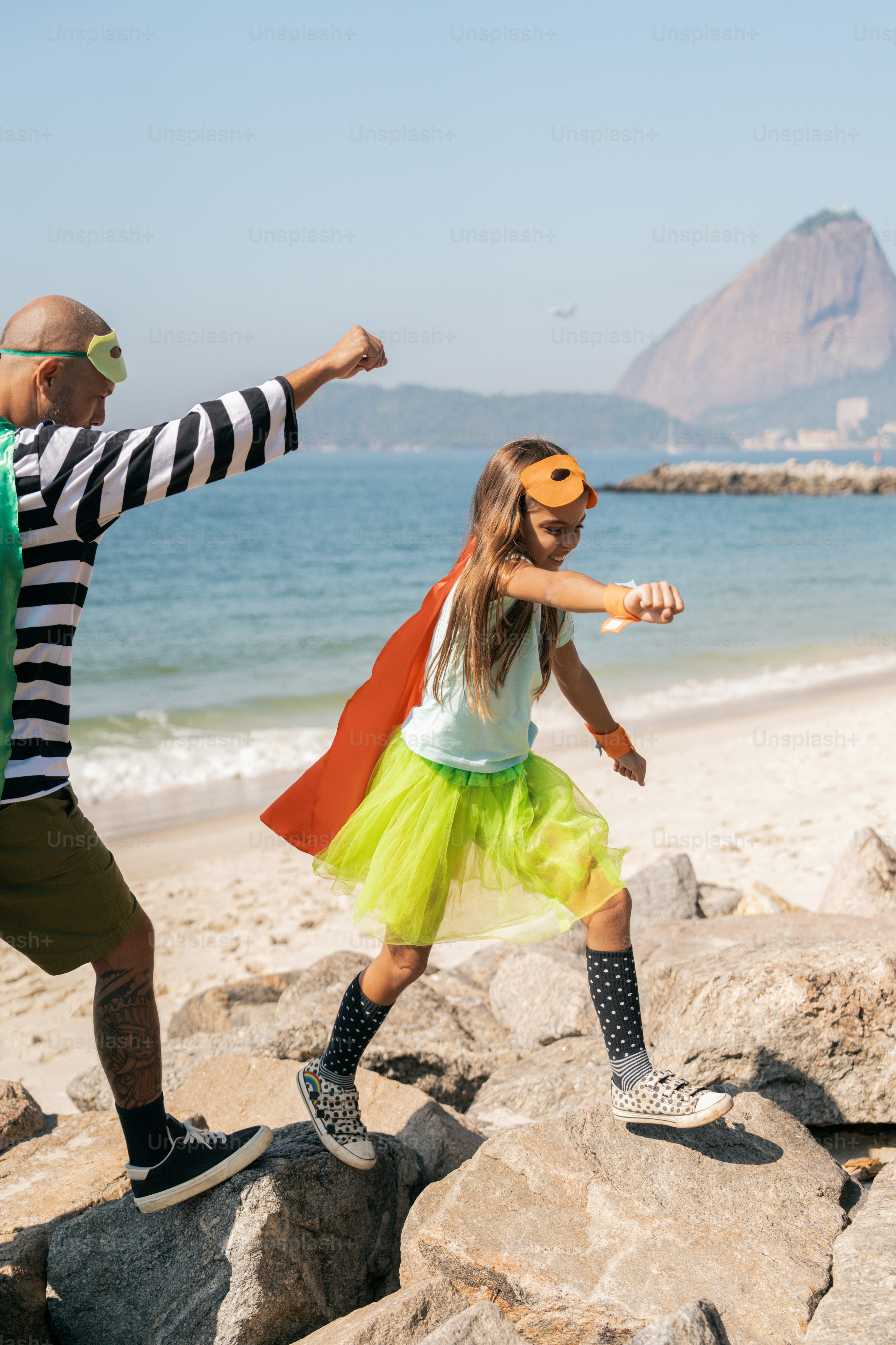 Um homem e uma menina brincando na praia