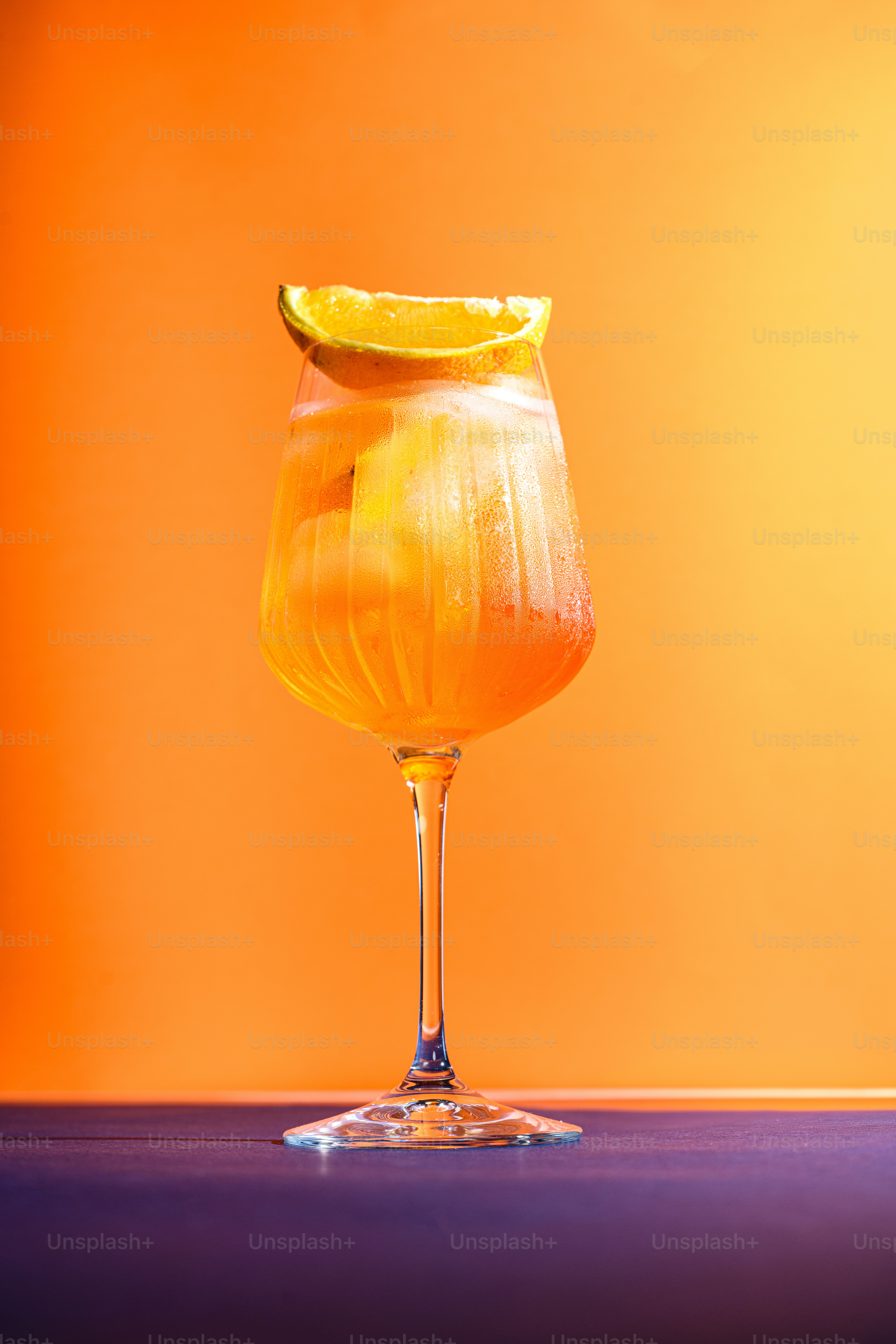 A glass of orange juice with a slice of lemon on top