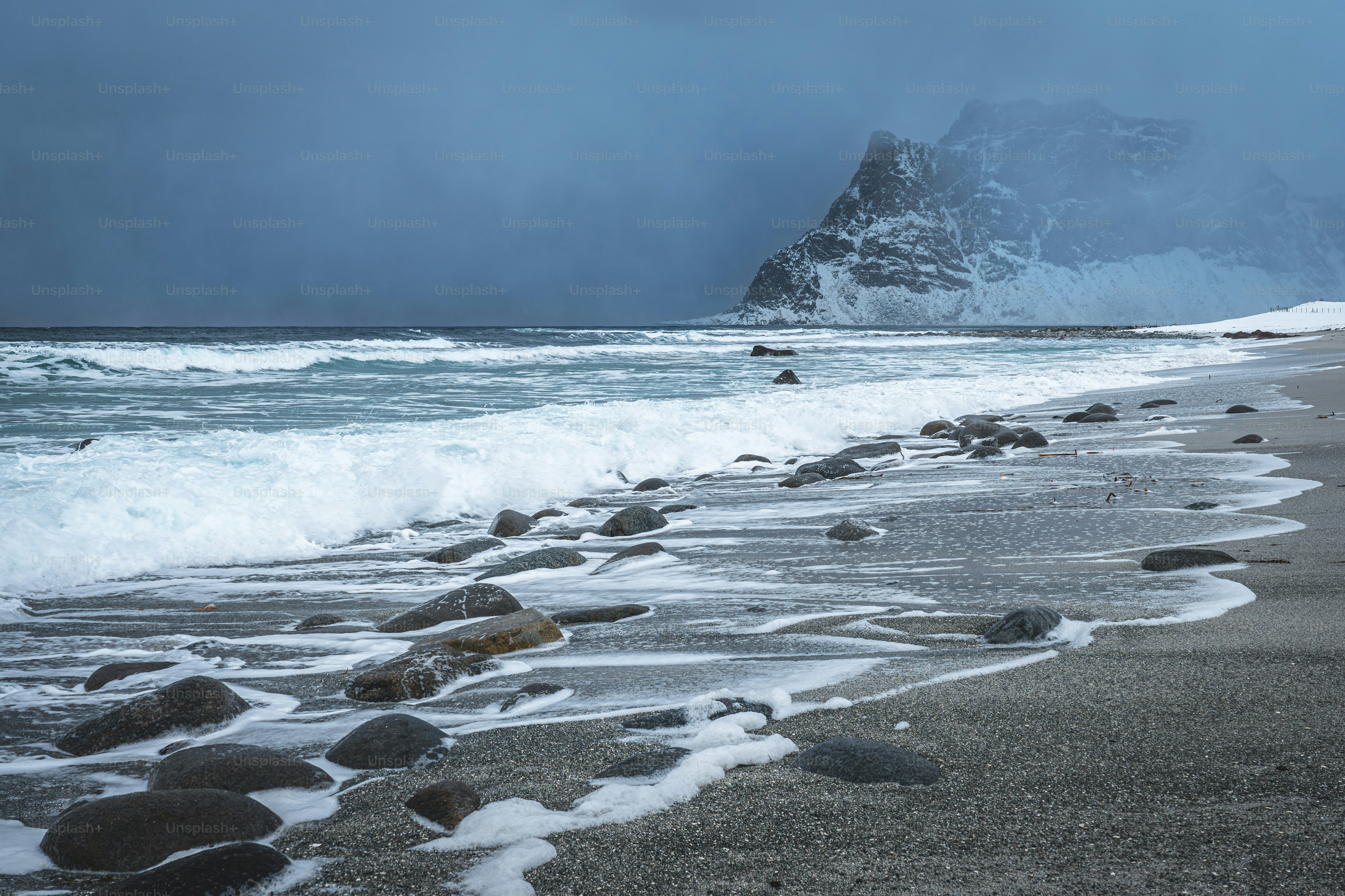 A rocky beach with waves crashing on the shore