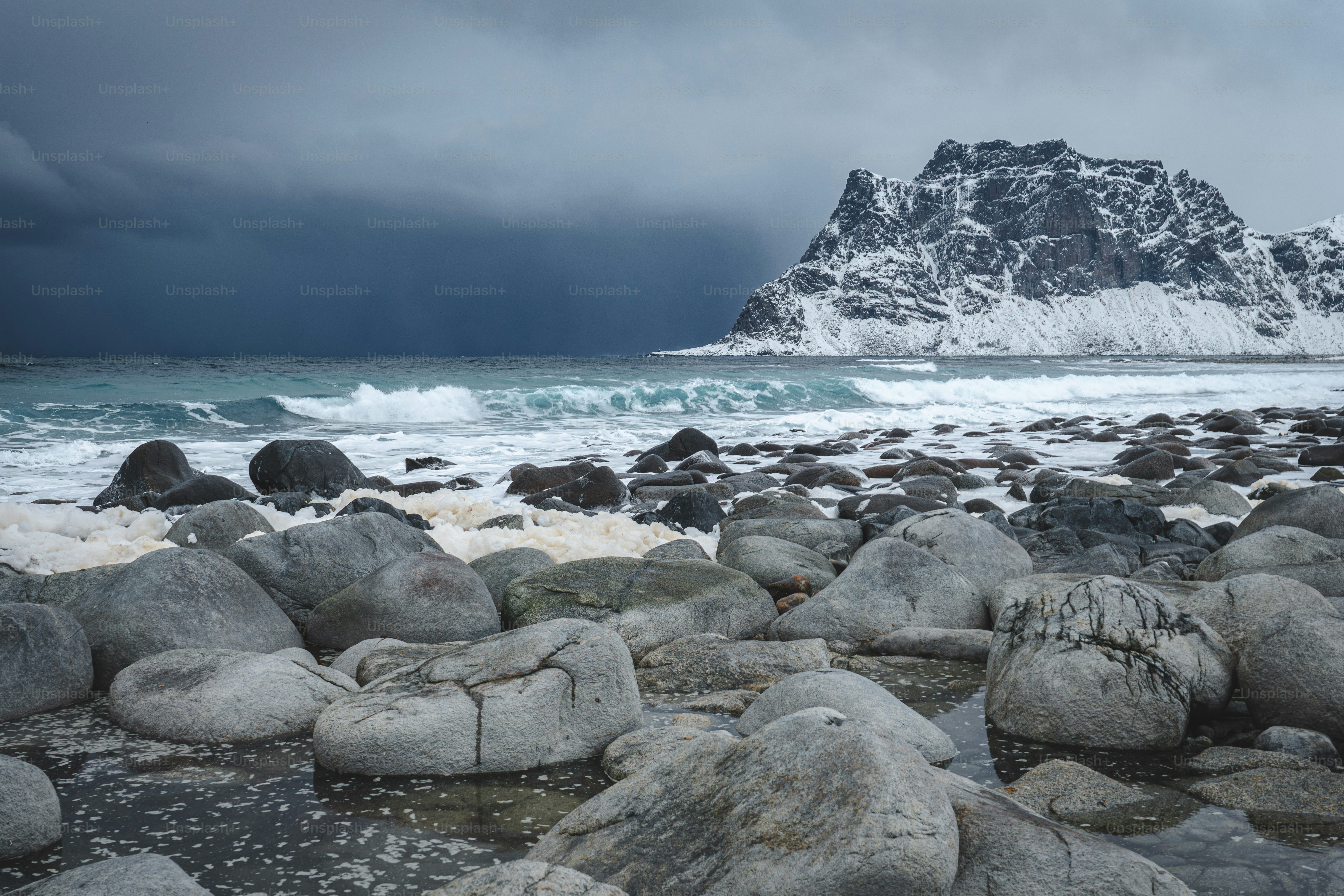 A rocky beach with a mountain in the background