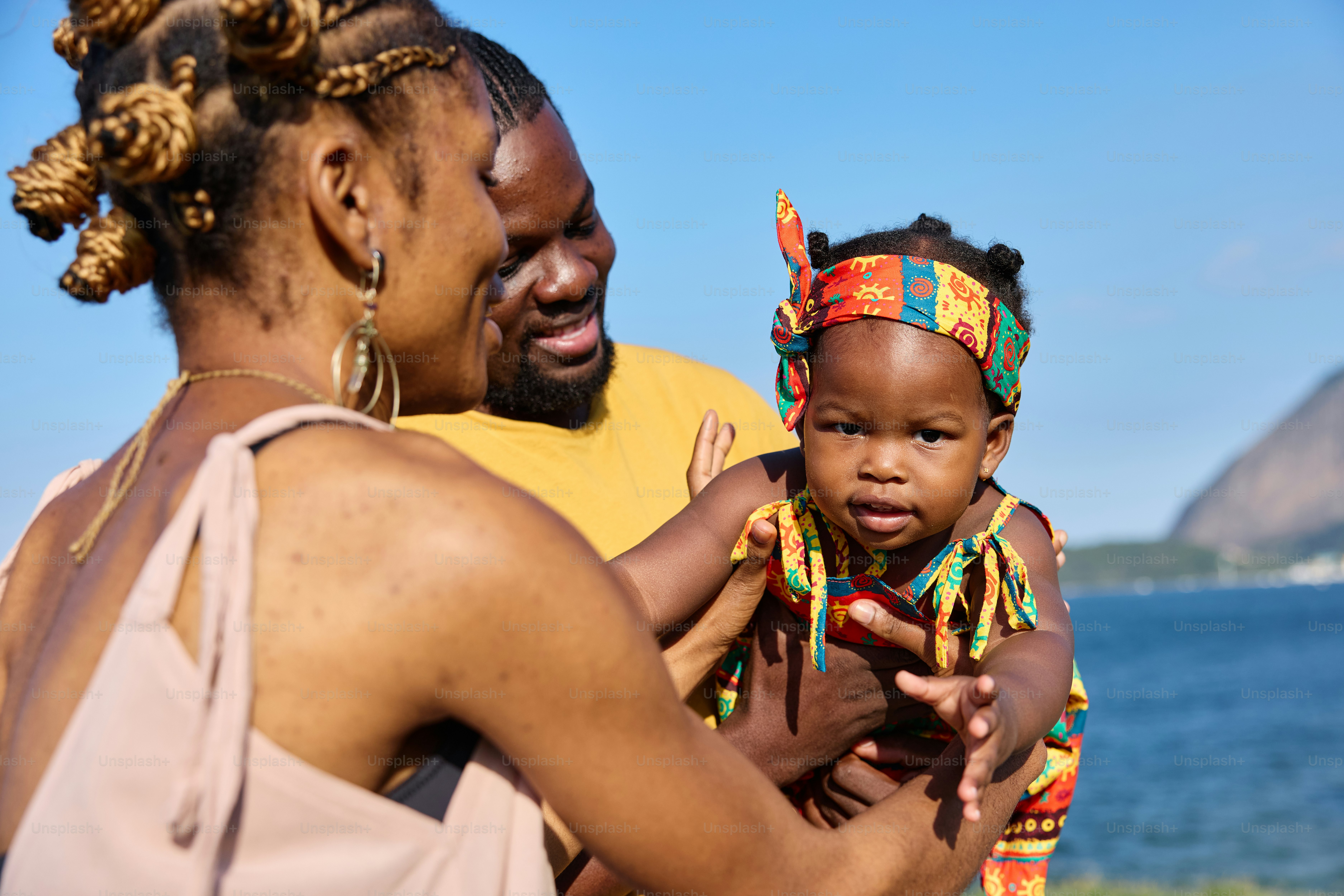 Una mujer sosteniendo a un bebé cerca del océano