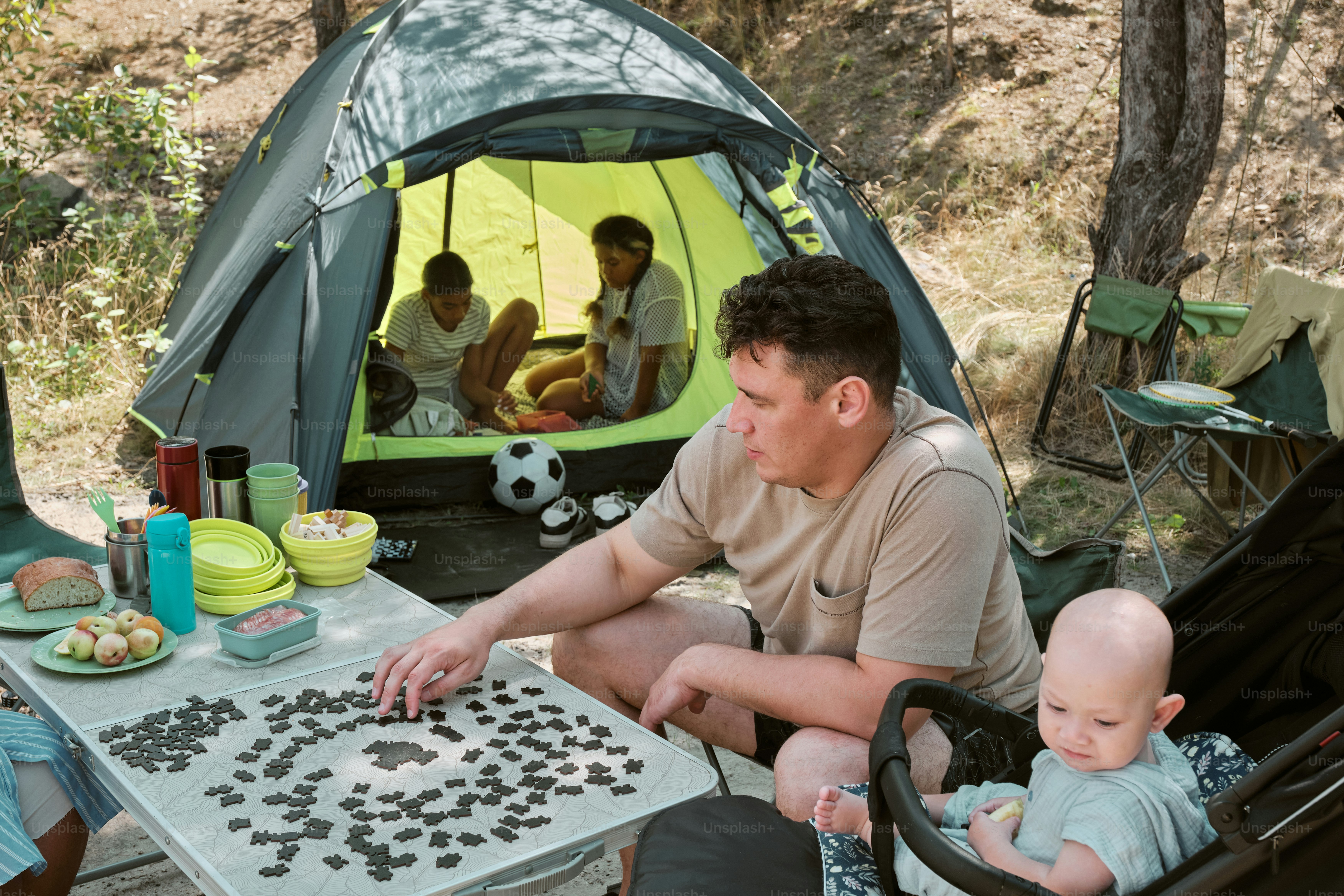 A man sitting in a chair next to a baby