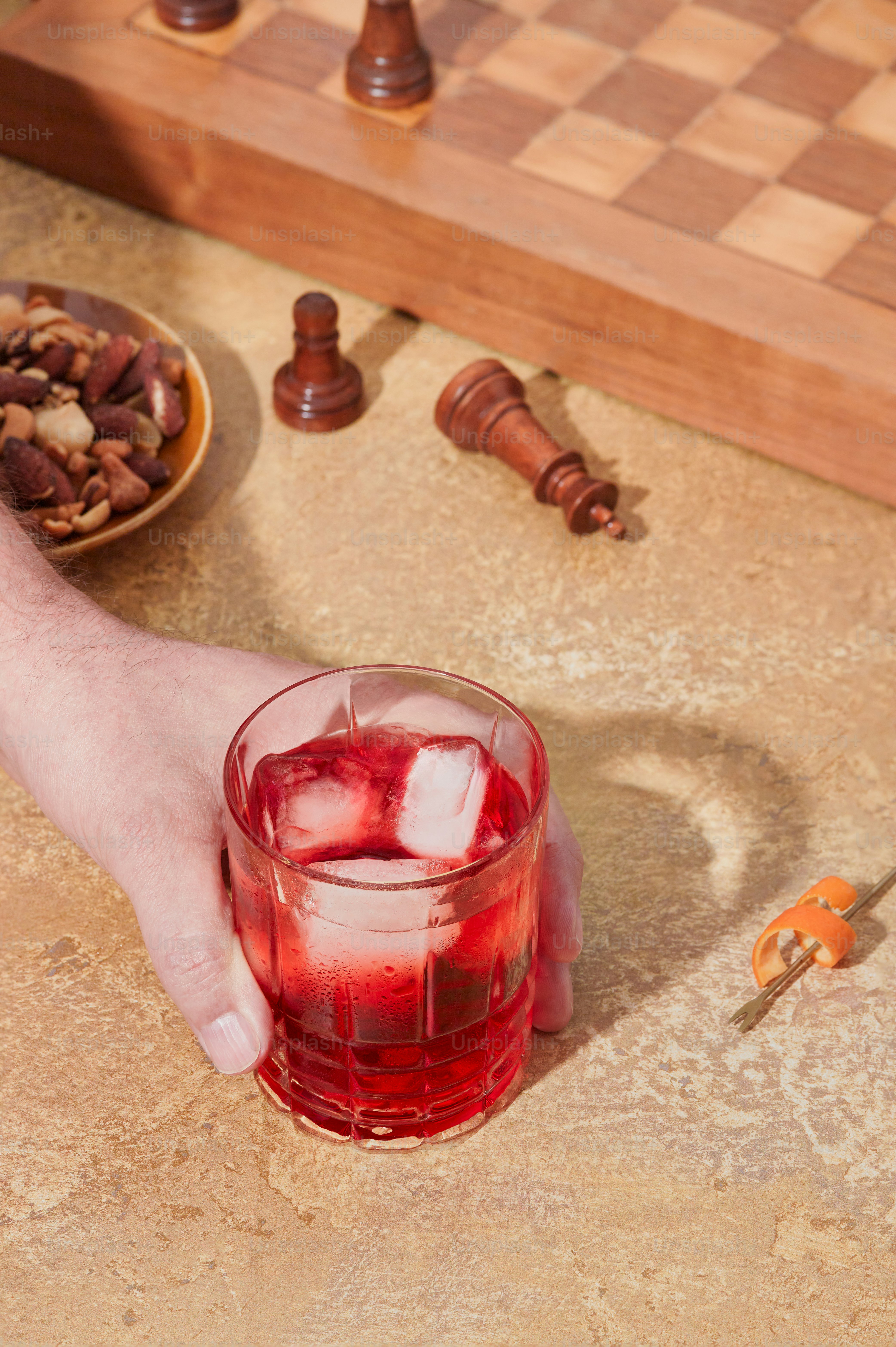 A person holding a glass of red liquid