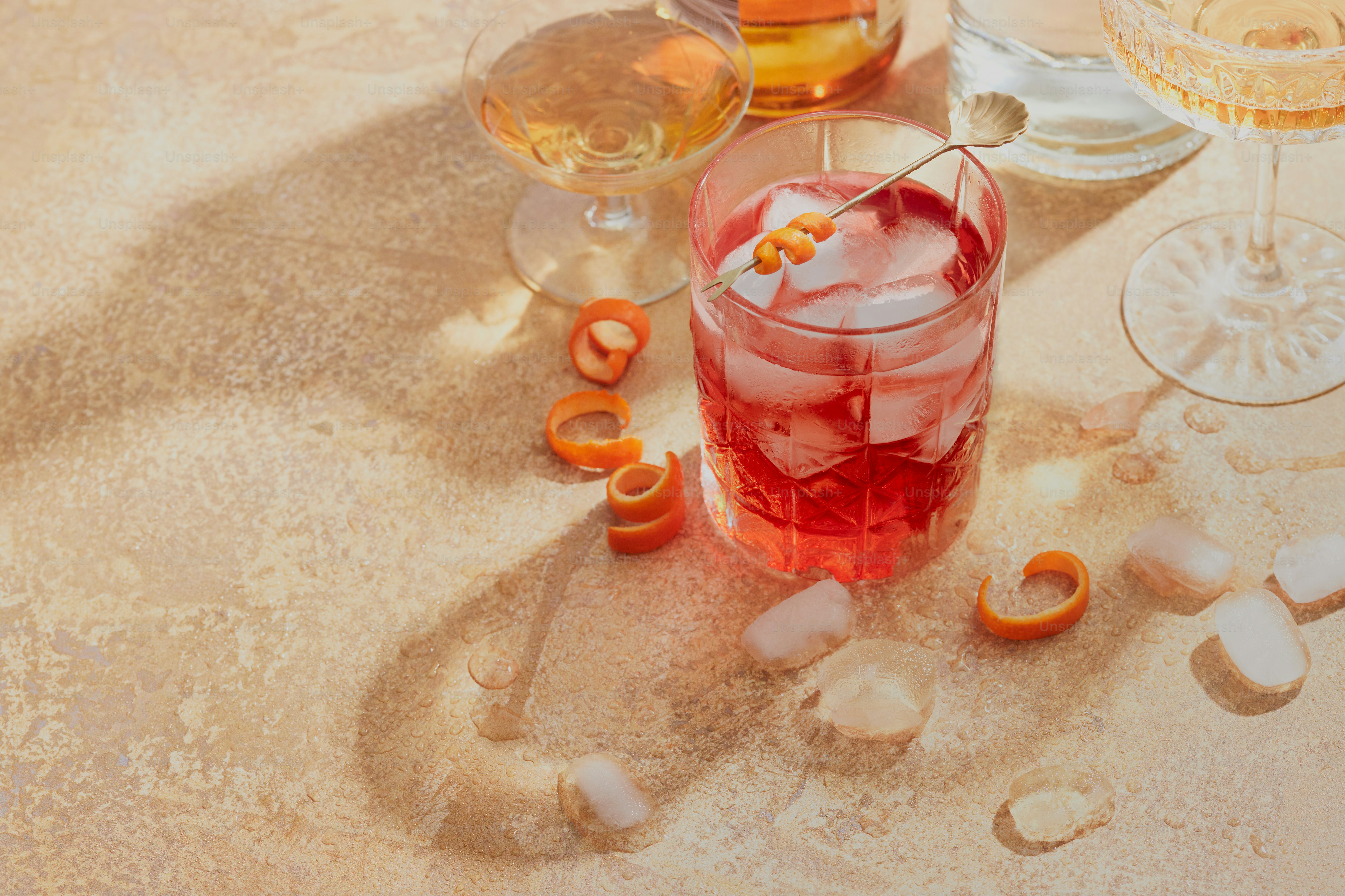 A table topped with glasses of wine and orange peels