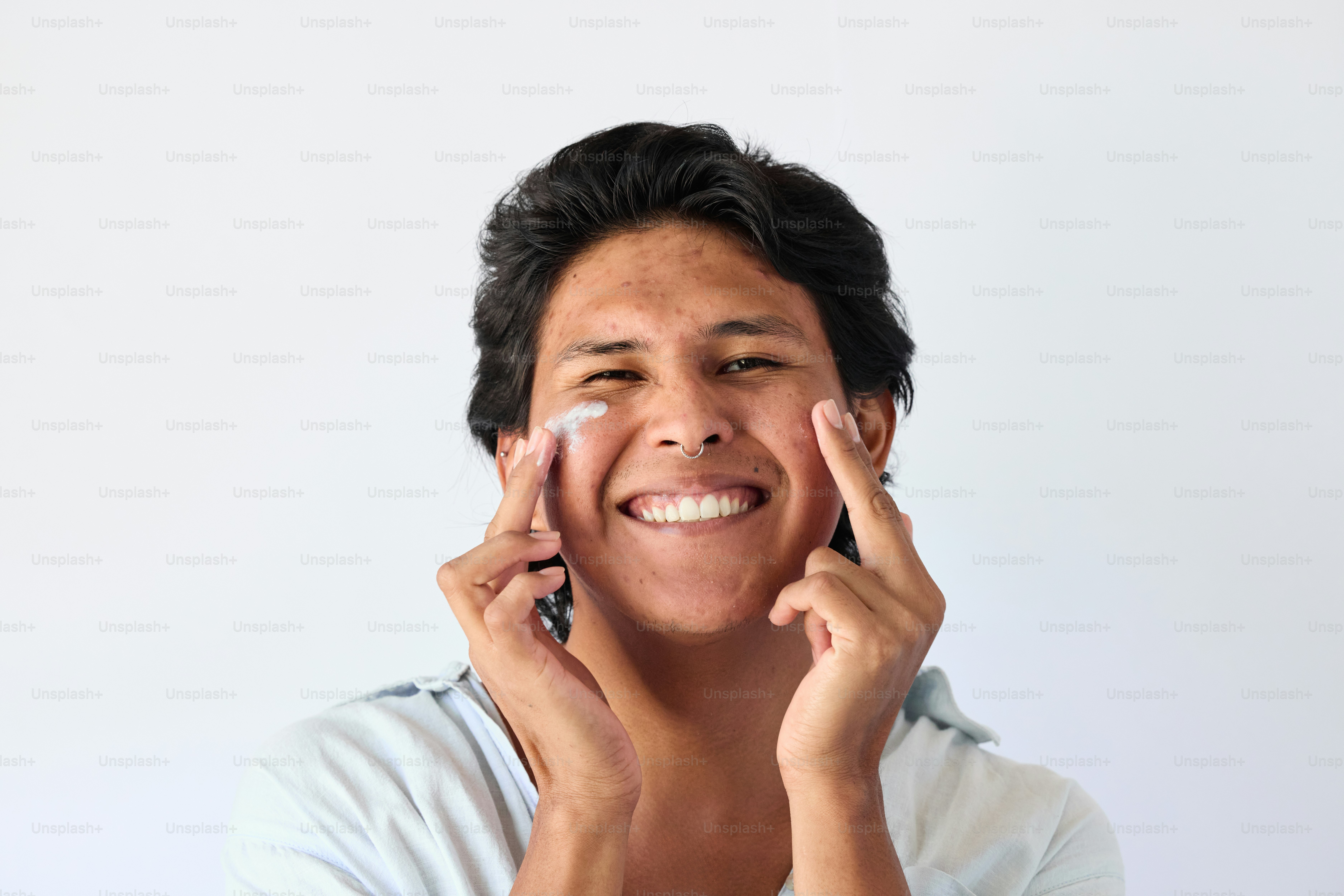 A man smiling while holding his hands to his face photo – Man Image on ...