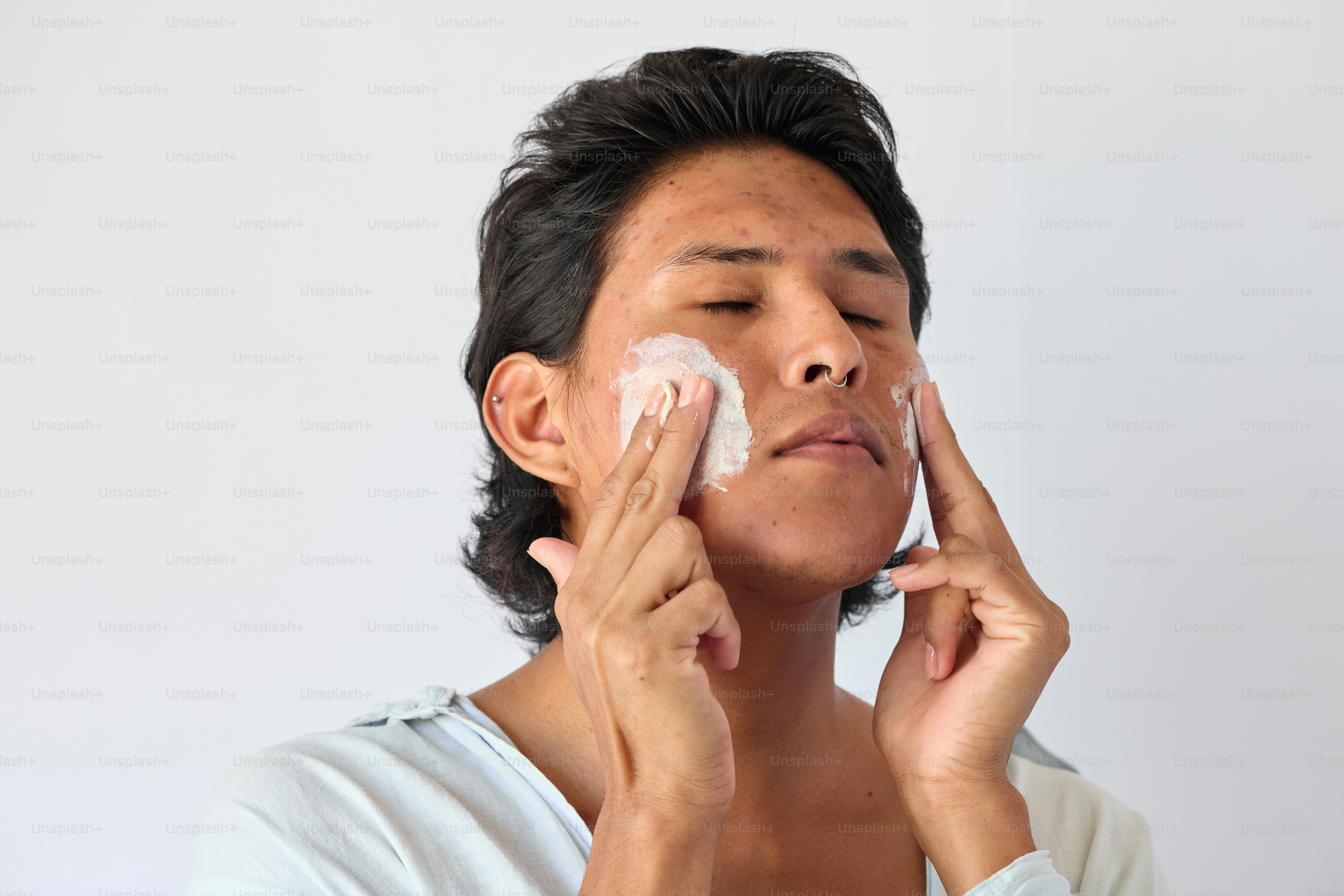 A man shaving his face with an electric razor photo – Man Image on Unsplash