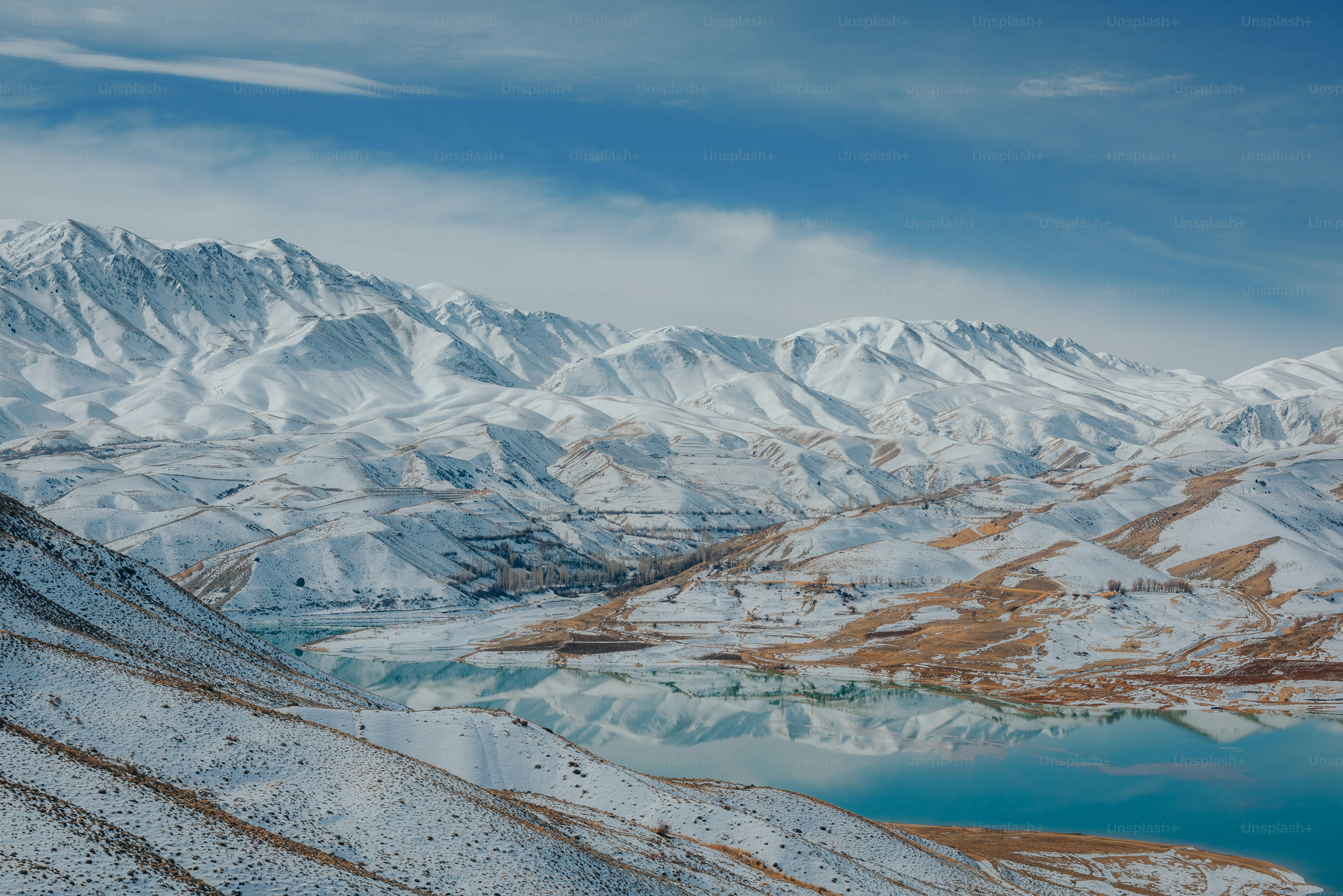 A man riding a snowboard down the side of a snow covered slope