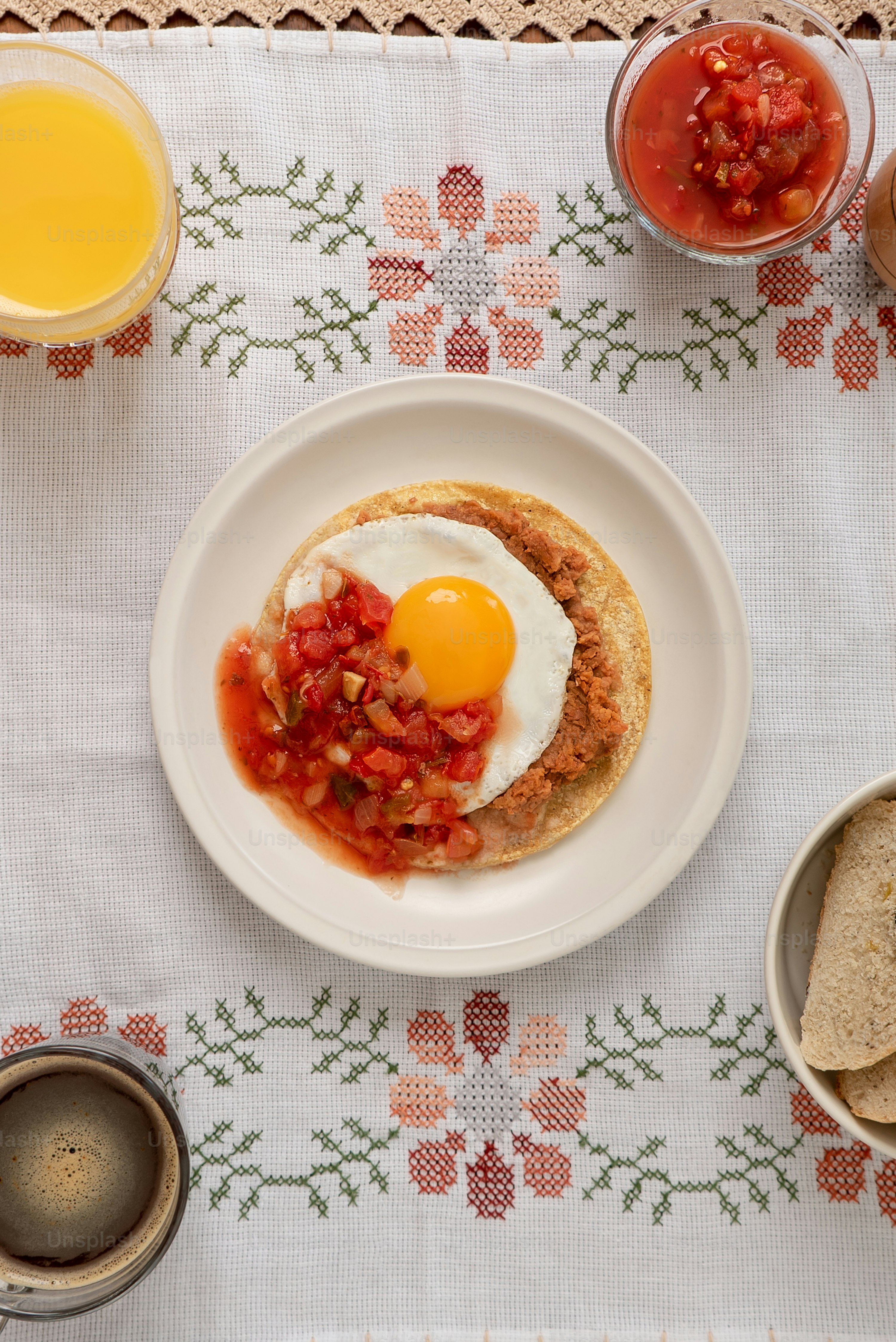 A table topped with a plate of food and cups of juice