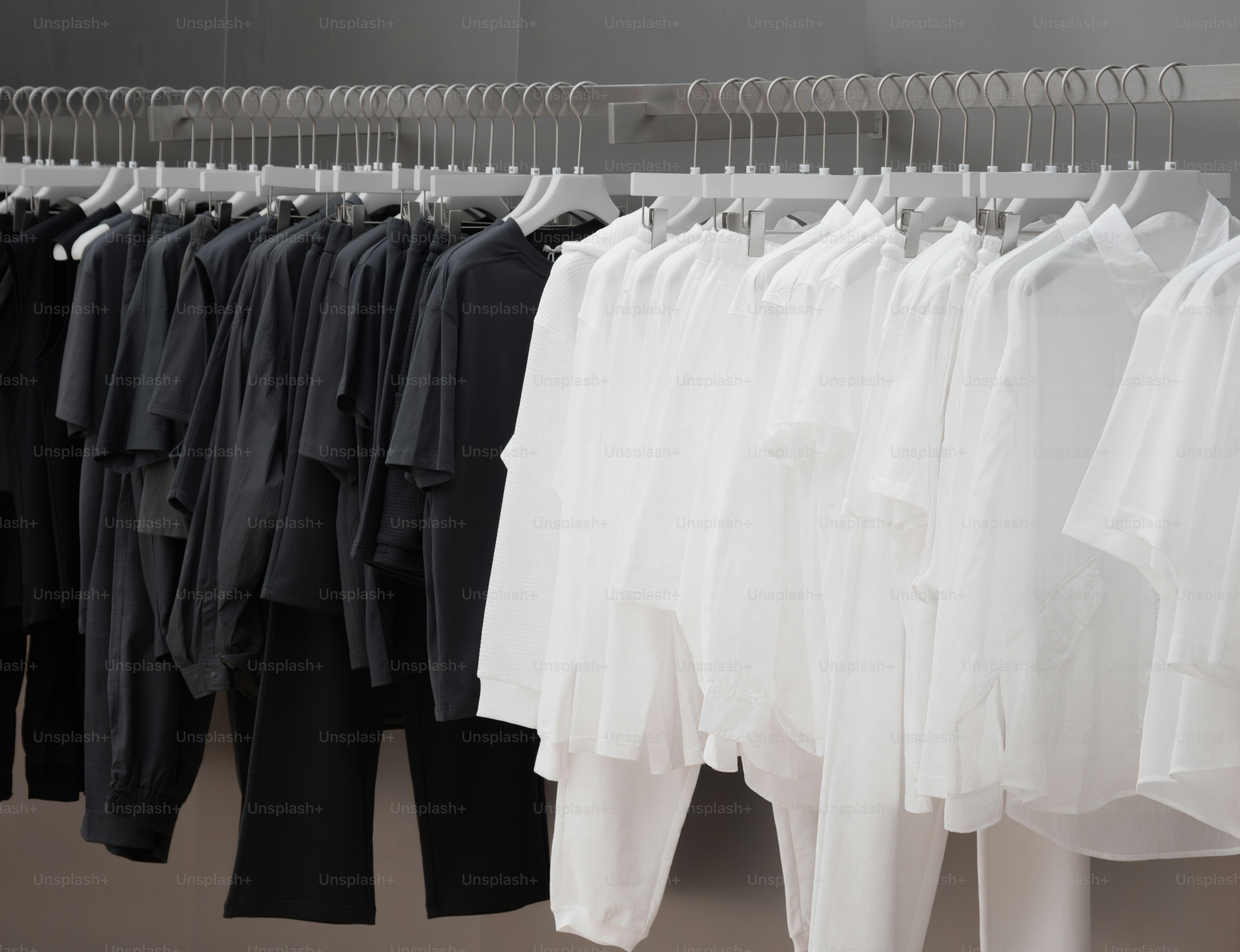 A rack of white and black shirts and pants