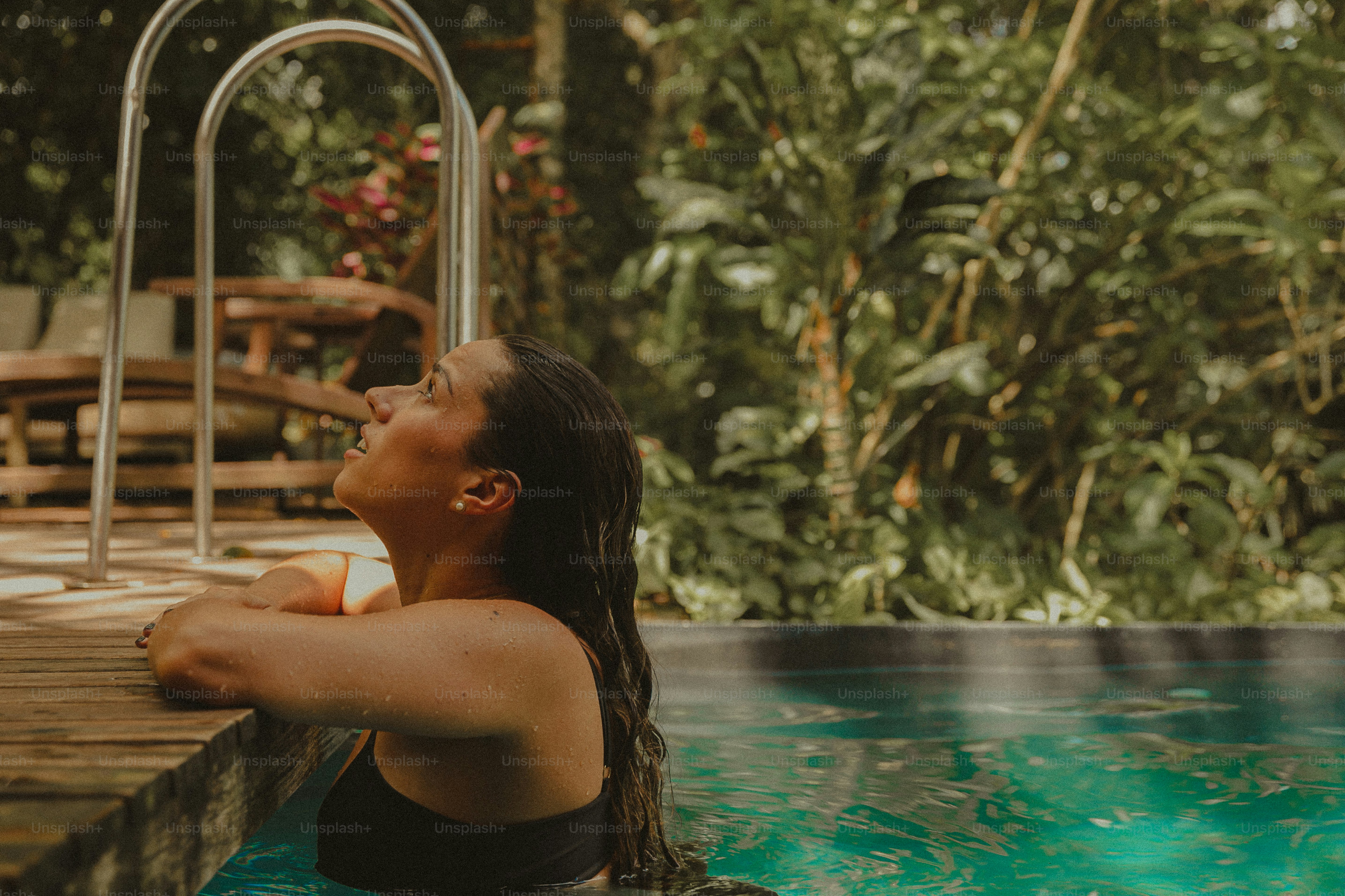 A woman in a black bathing suit sitting in a pool