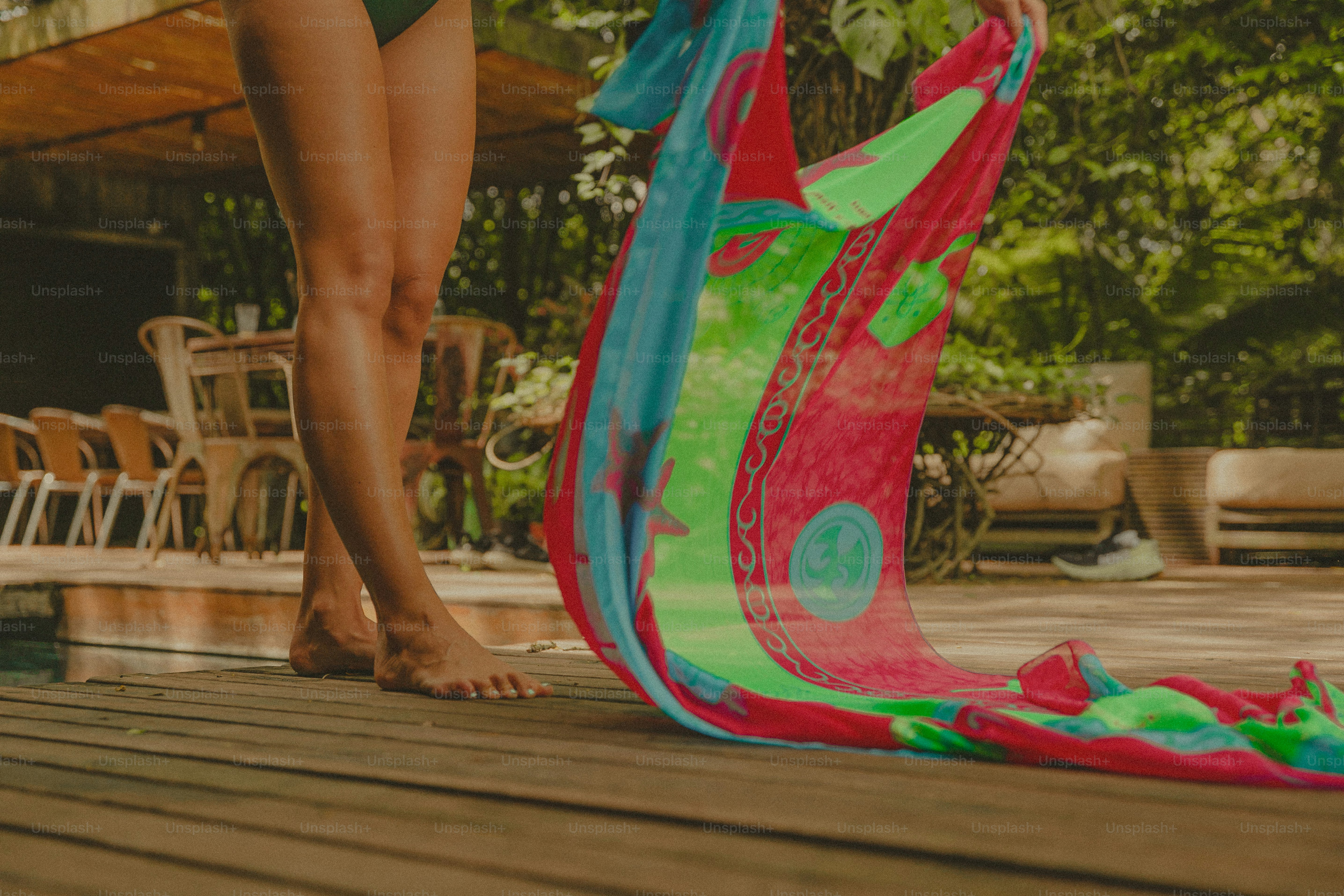 A woman in a bikini standing next to a colorful kite