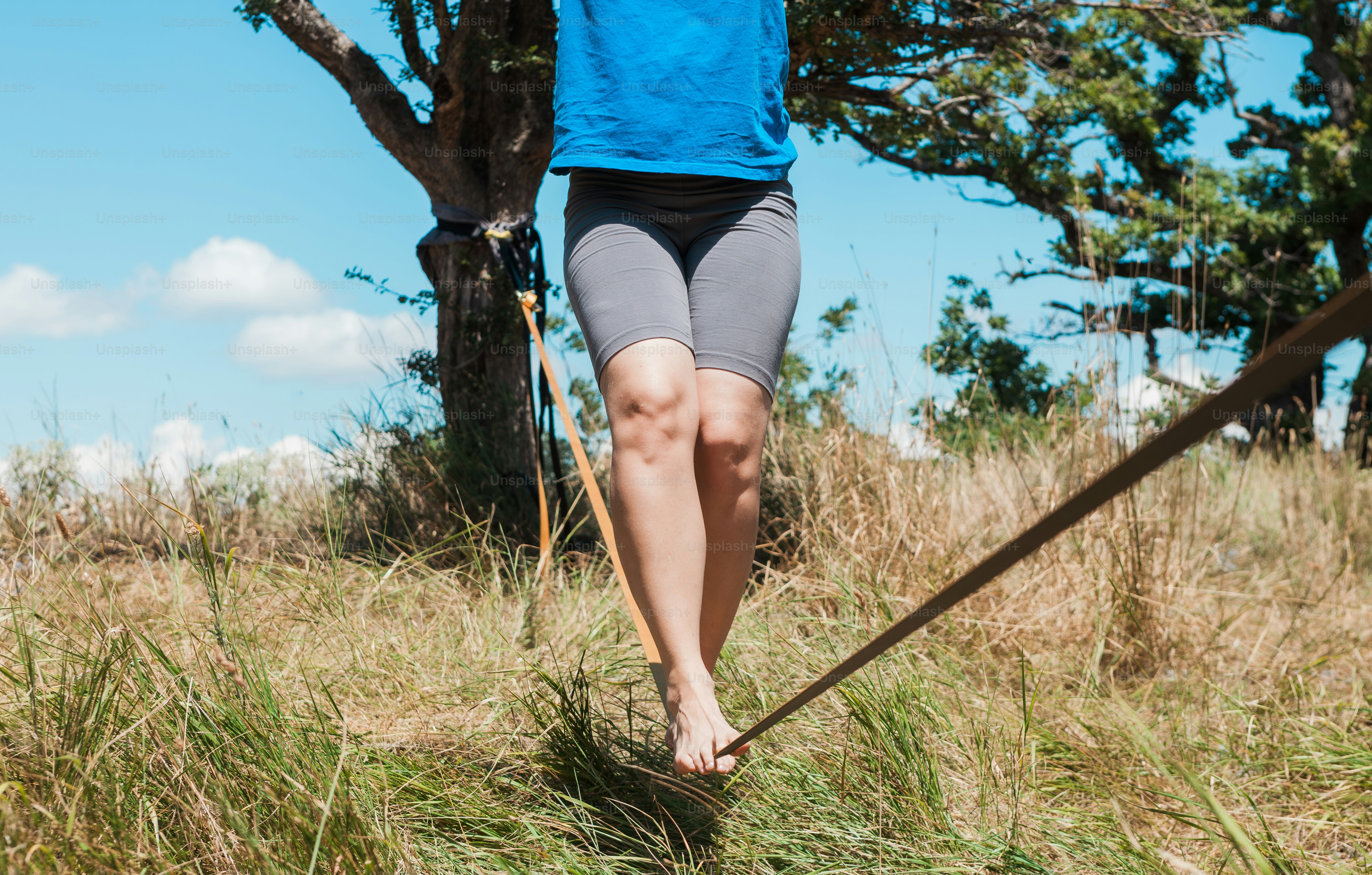 A woman in a blue shirt is walking in the grass