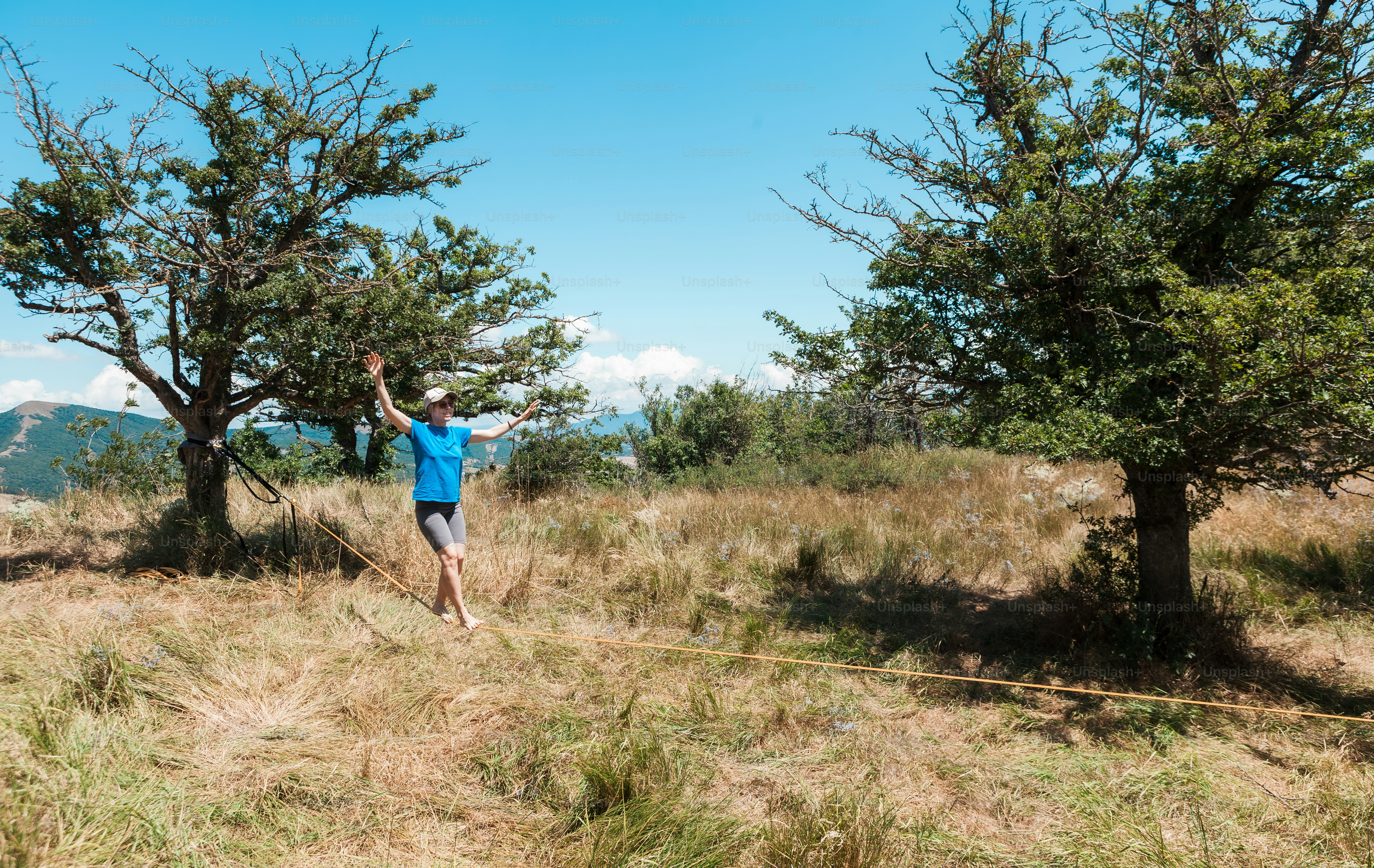 A man standing on top of a grass covered field photo – Slackline Image ...
