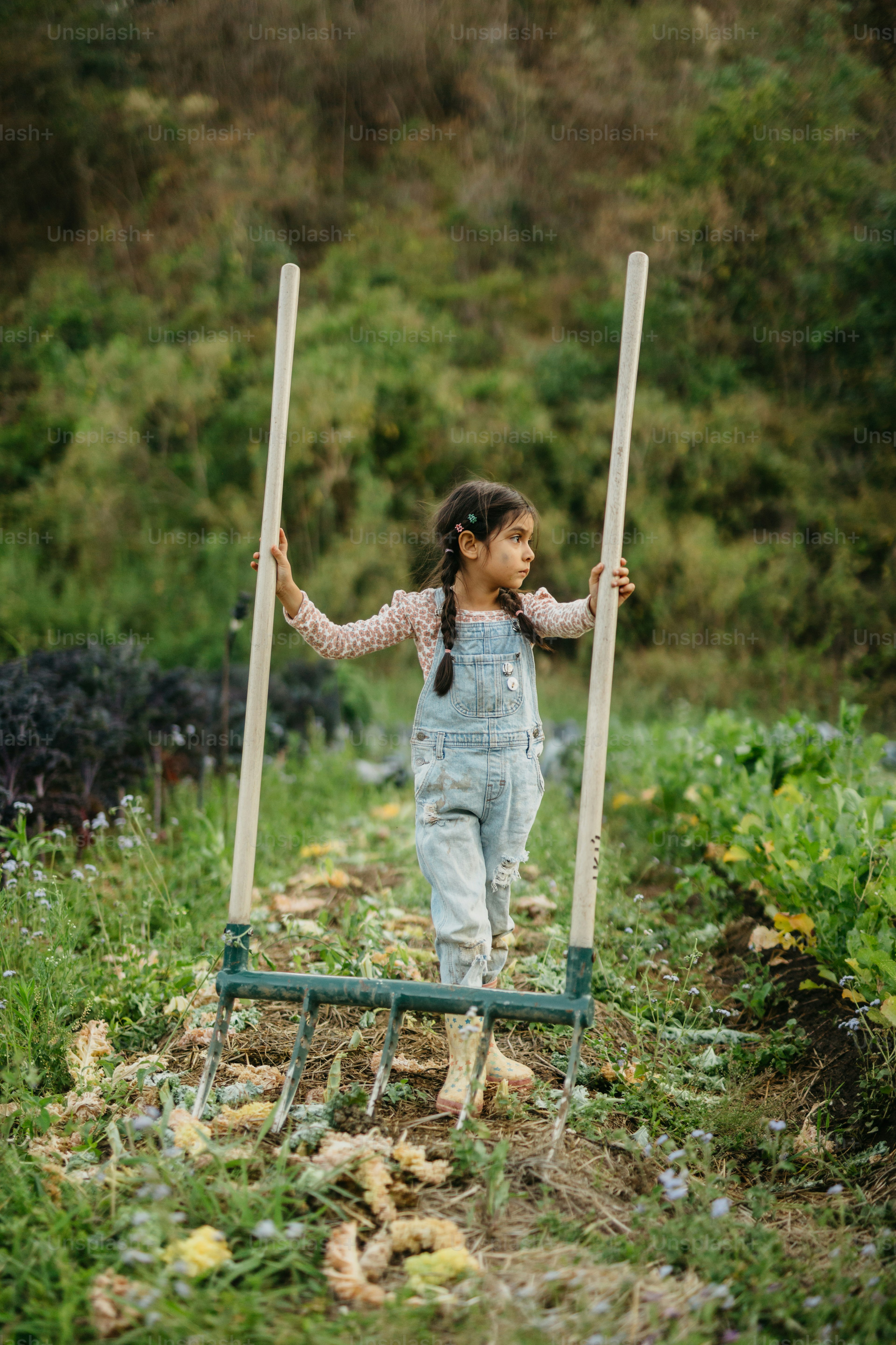 Una bambina in piedi sopra una panchina verde