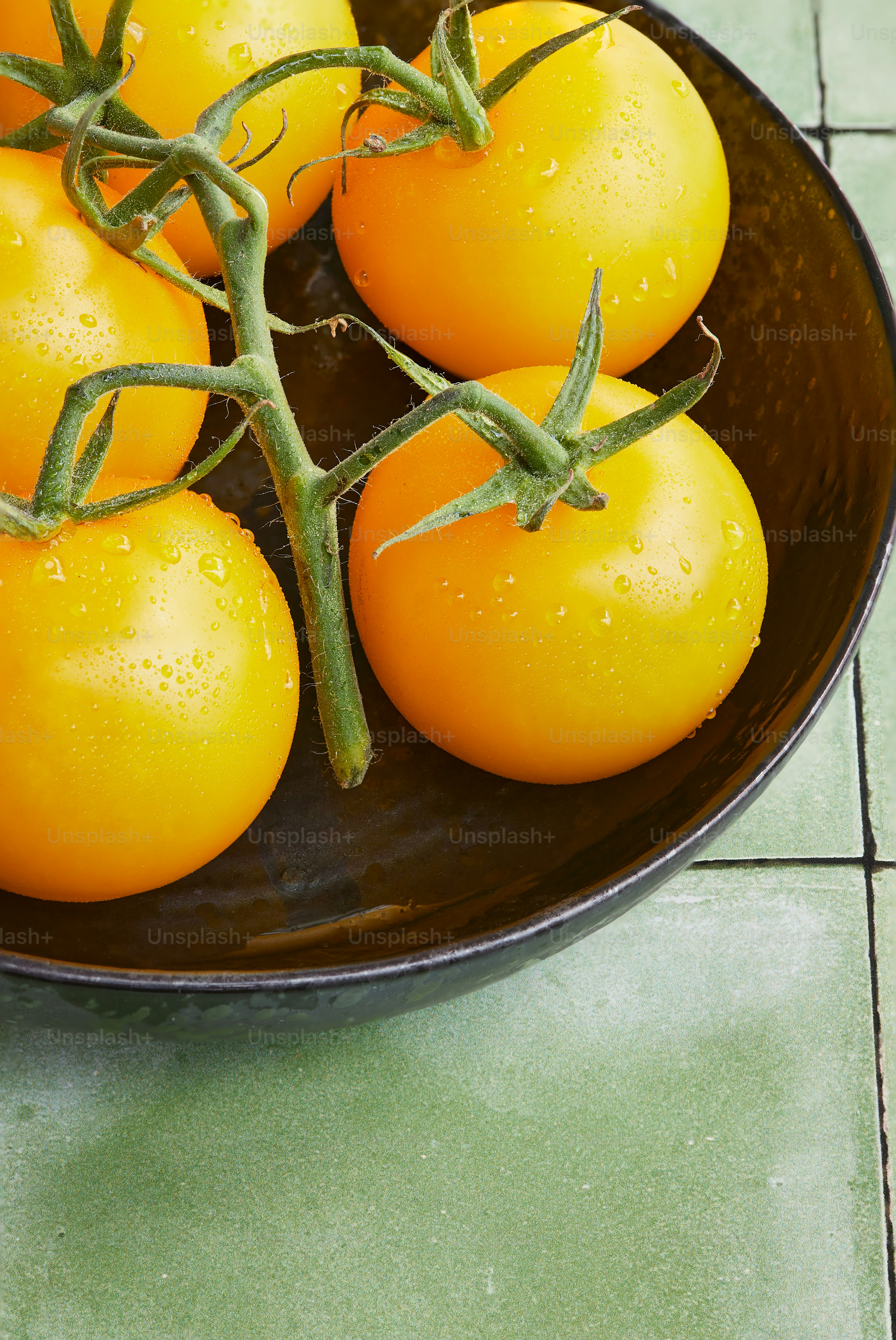 Un bol rempli de beaucoup de tomates orange mûres